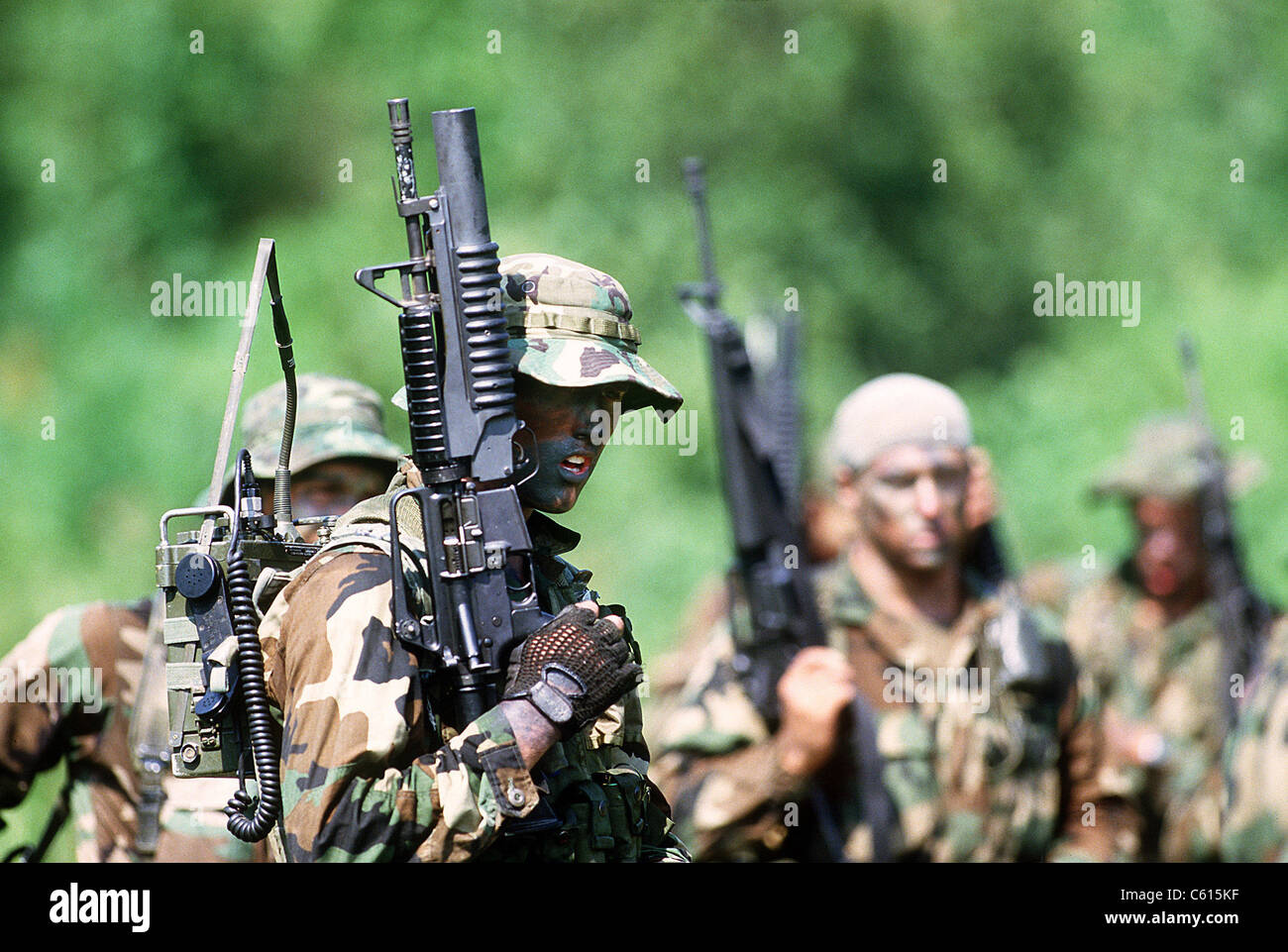 US Navy SEALs in warfare training. Foreground SEAL carries a field radio and a Colt Commando assault rifle equipped with an M-203 grenade launcher. Aug. 1 1987. (BSLOC 2011 12 274) Stock Photo