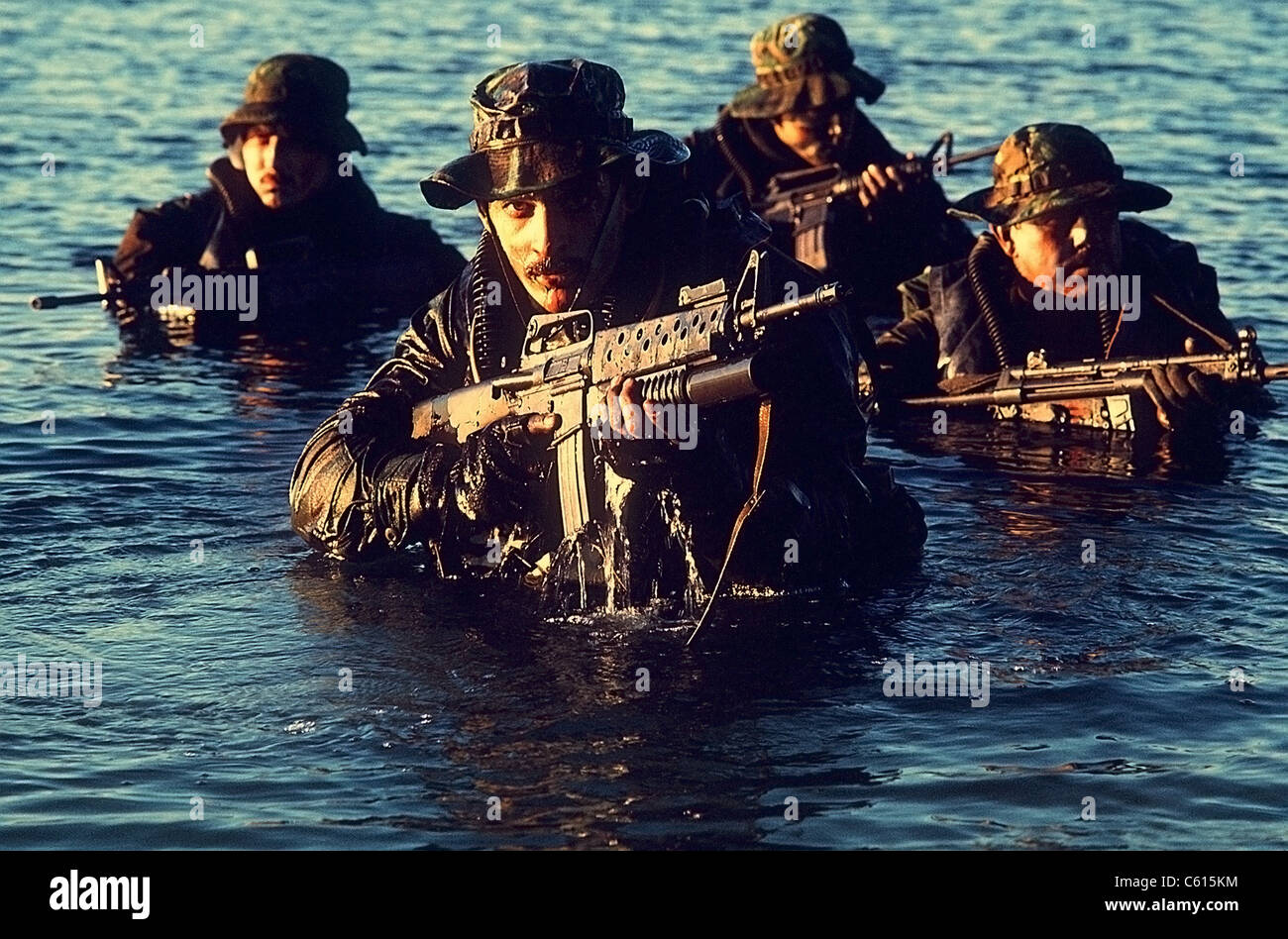 US Navy SEAL team emerges from water during warfare training. Foreground SEAL is armed with an M-16 rifle equipped with a grenade launcher. Dec. 1 1986. (BSLOC 2011 12 275) Stock Photo