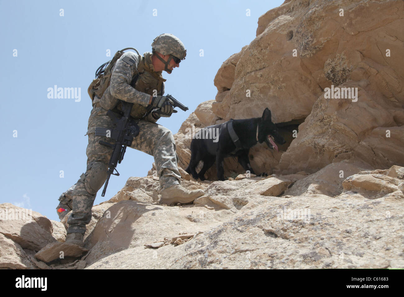 US soldier and Blek a working dog clear caves and search for weapons in the Zirat Mountain Area Afghanistan. July 7 2010. Stock Photo