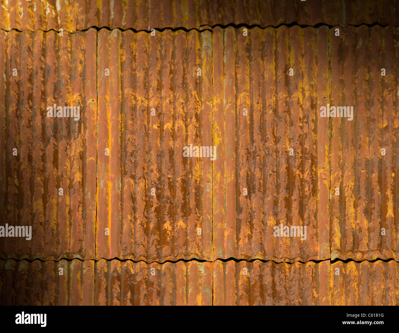 Corroded and rusty corrugated metal roof panels lit diagonally Stock Photo