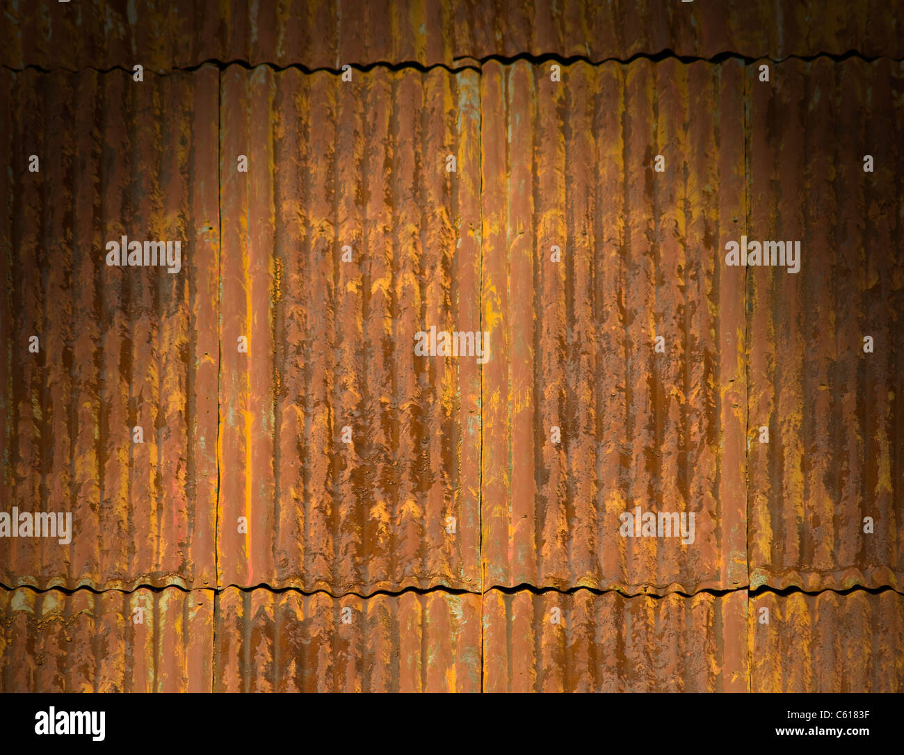 Corroded and rusty corrugated metal roof panels lit dramatically Stock Photo