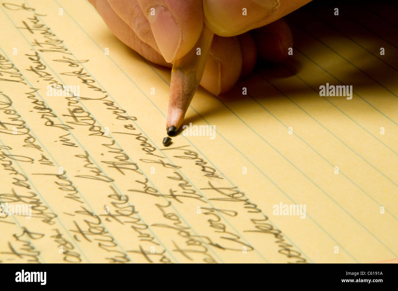 Handwriting with broken pencil point on yellow legal pad Stock Photo