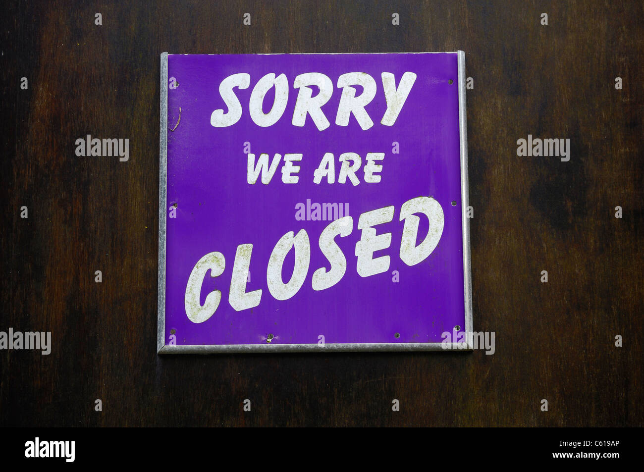 Sorry we are closed sign pinned to a wooden door. Stock Photo