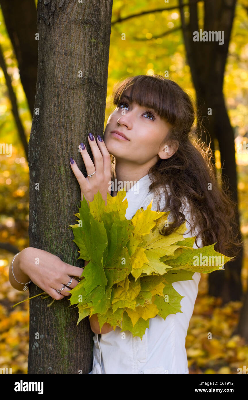 The woman with a bouquet of yellow leaves near a tree Stock Photo - Alamy