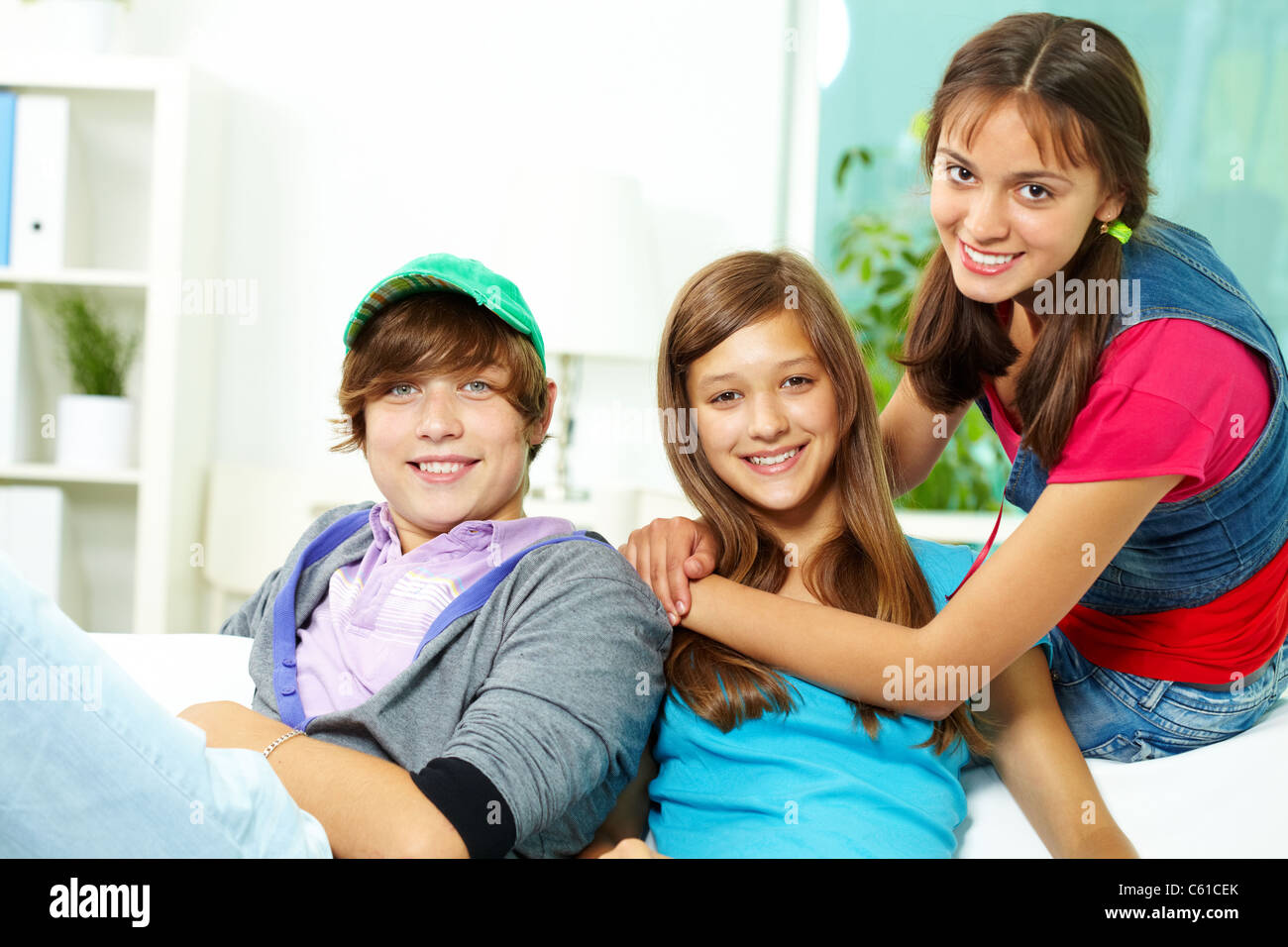 Young home. Teenager friends sitting together and laughing stock photo.