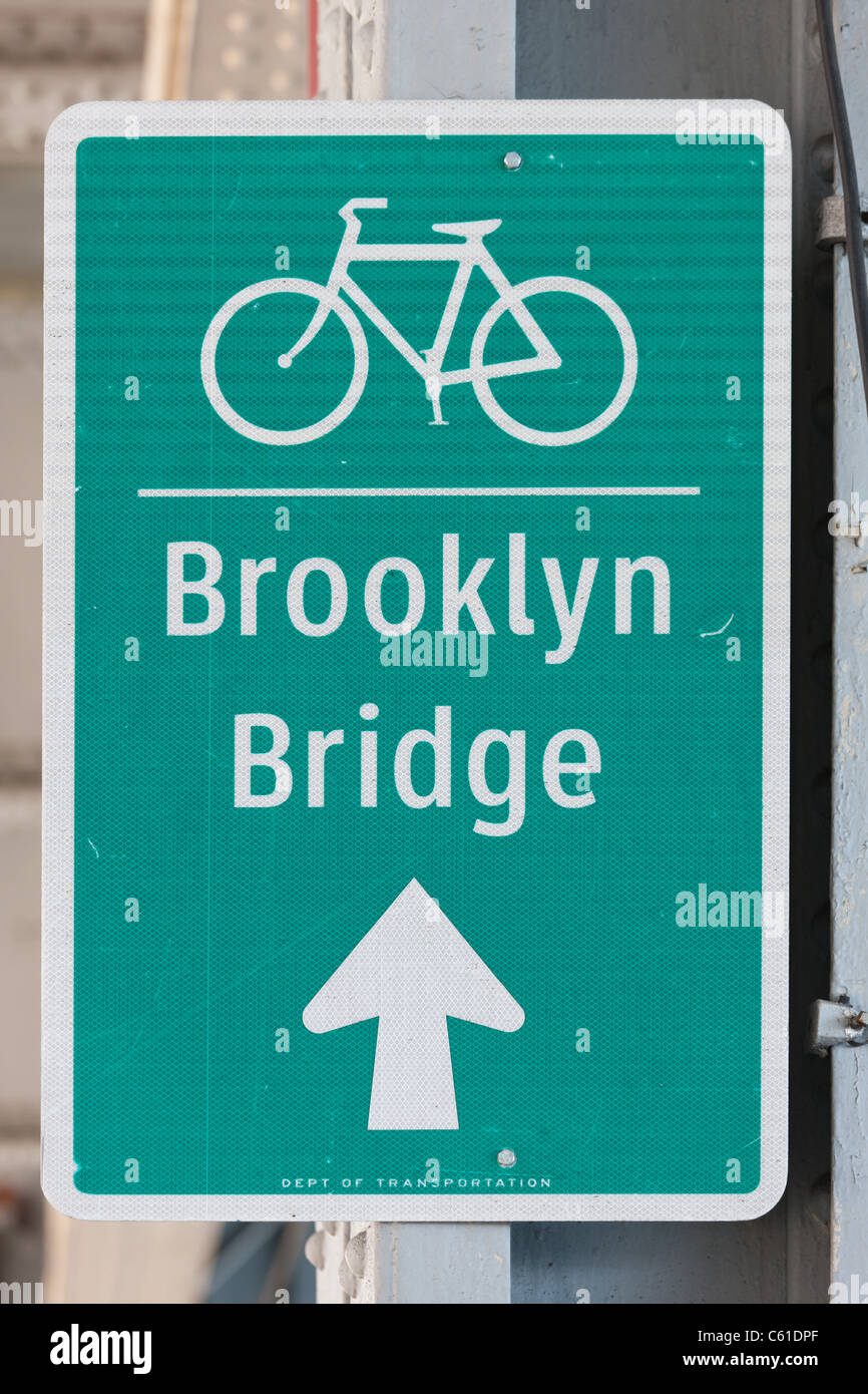 A sign directs cyclists to the bike lane across the Brooklyn Bridge. Stock Photo
