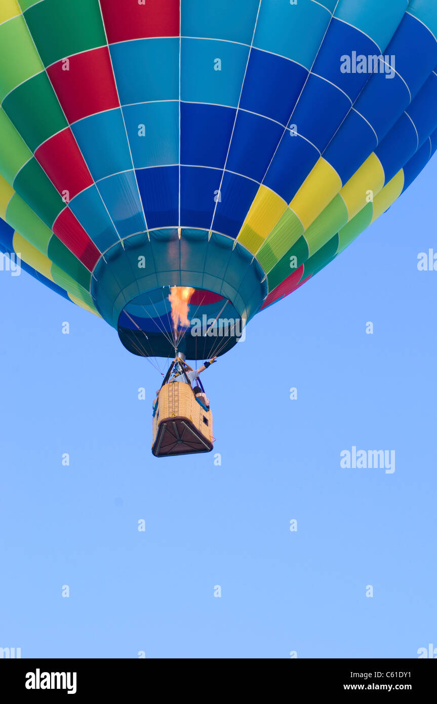 Hot-air balloon floating with view of gondola and burner ignition from below Stock Photo