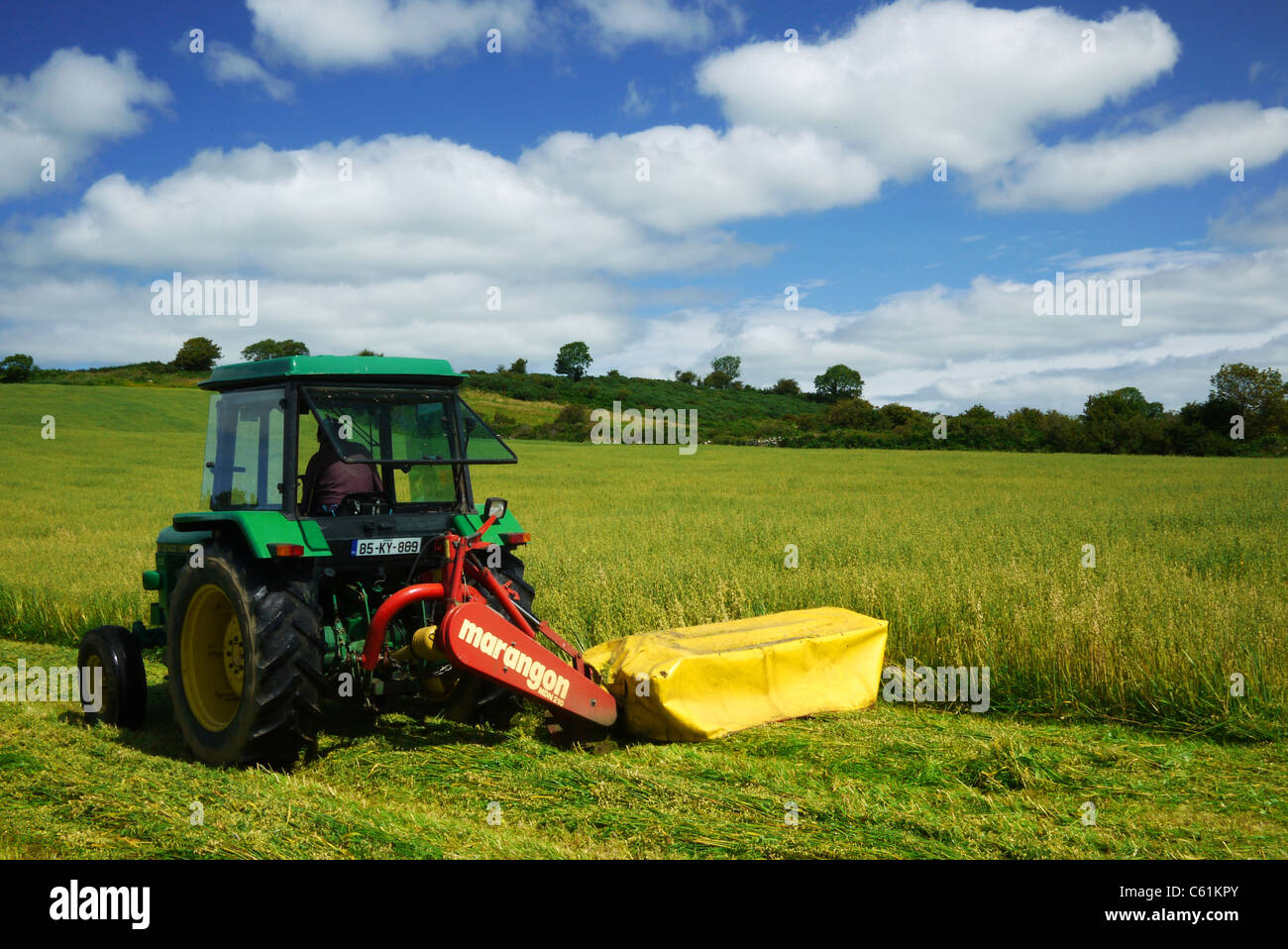 Farming in UK Ireland collecting the harvest cutting the oats on a tractor Stock Photo