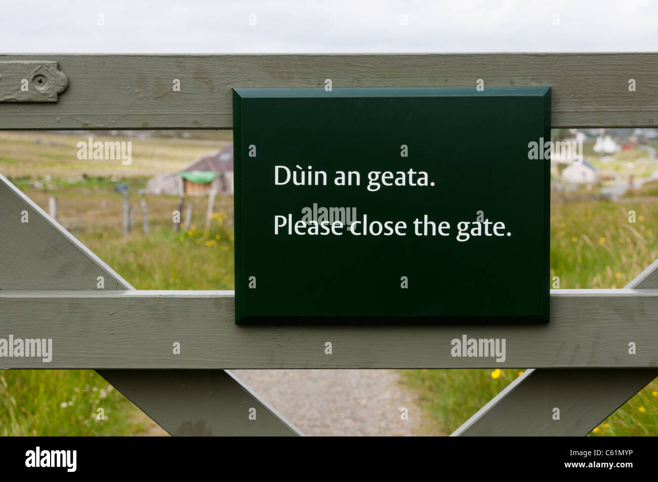 A bilingual sign says Please Close The Gate in English and Gaelic Stock Photo