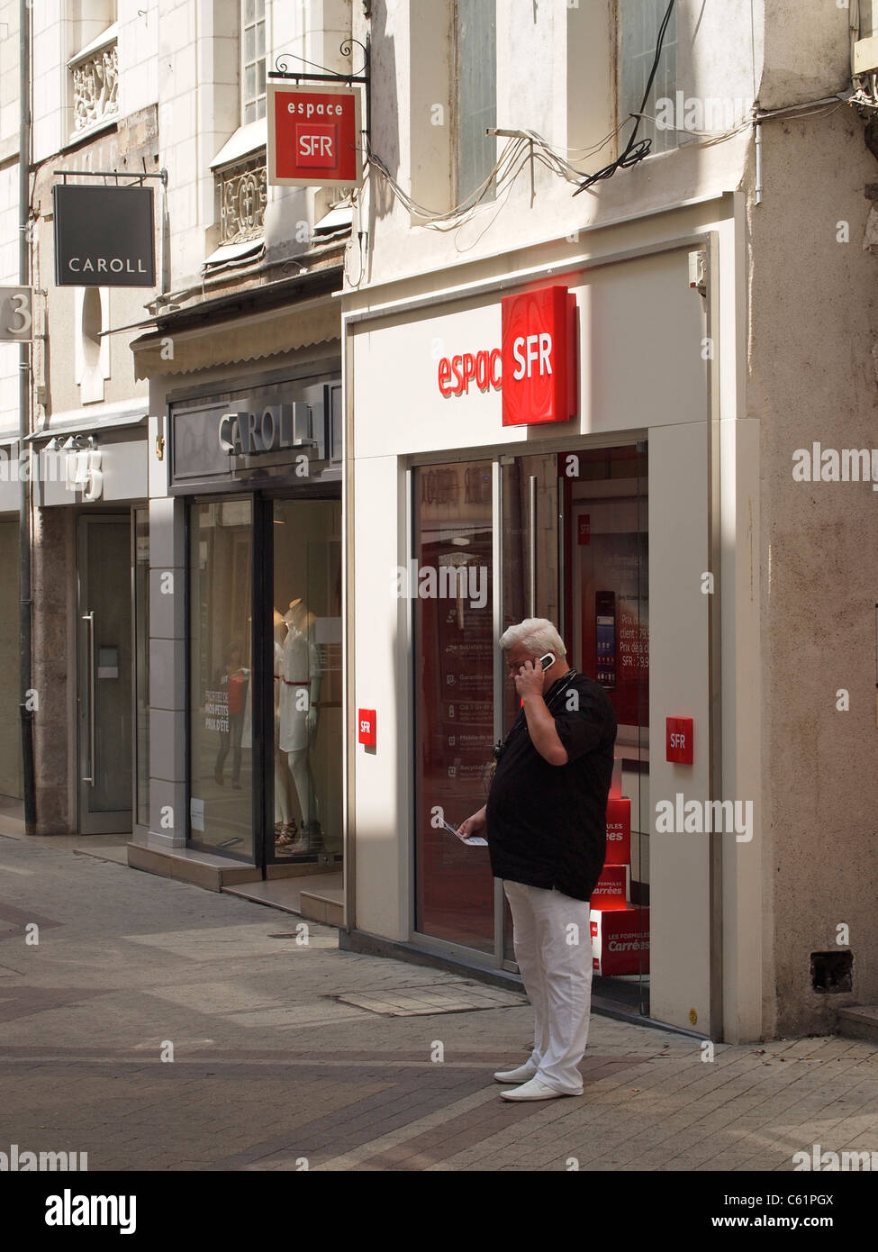 Man using his new mobile phone in front of the SFR shop in Blois, Loire valley, France Stock Photo