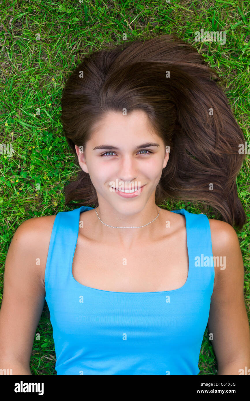 Cute young woman lying on grass in the park Stock Photo - Alamy