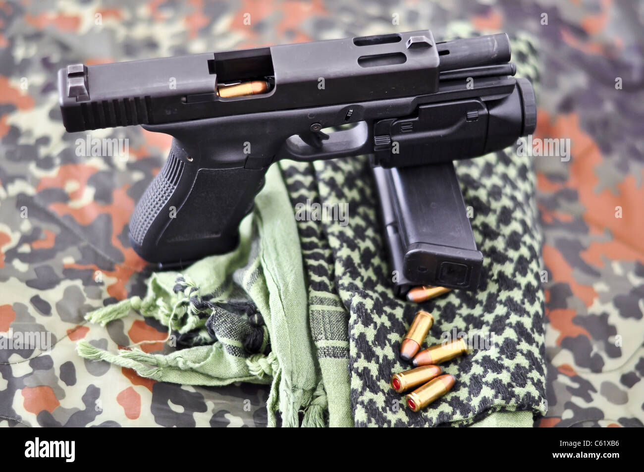 9mm military sidearm with a tactical laser/light-module on camouflage Stock Photo