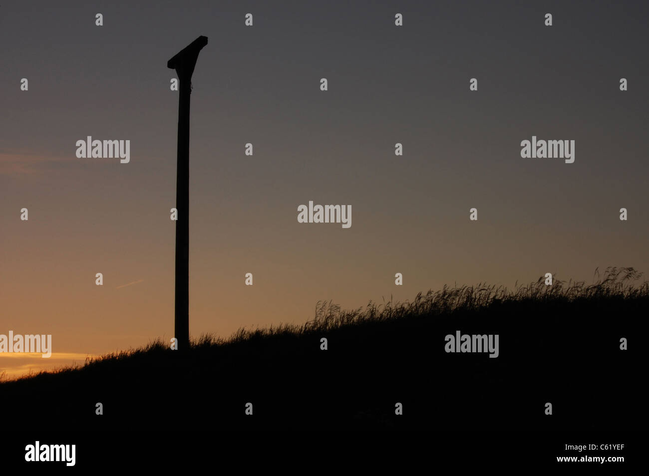 Combe Gibbet silhouetted against sunset Stock Photo