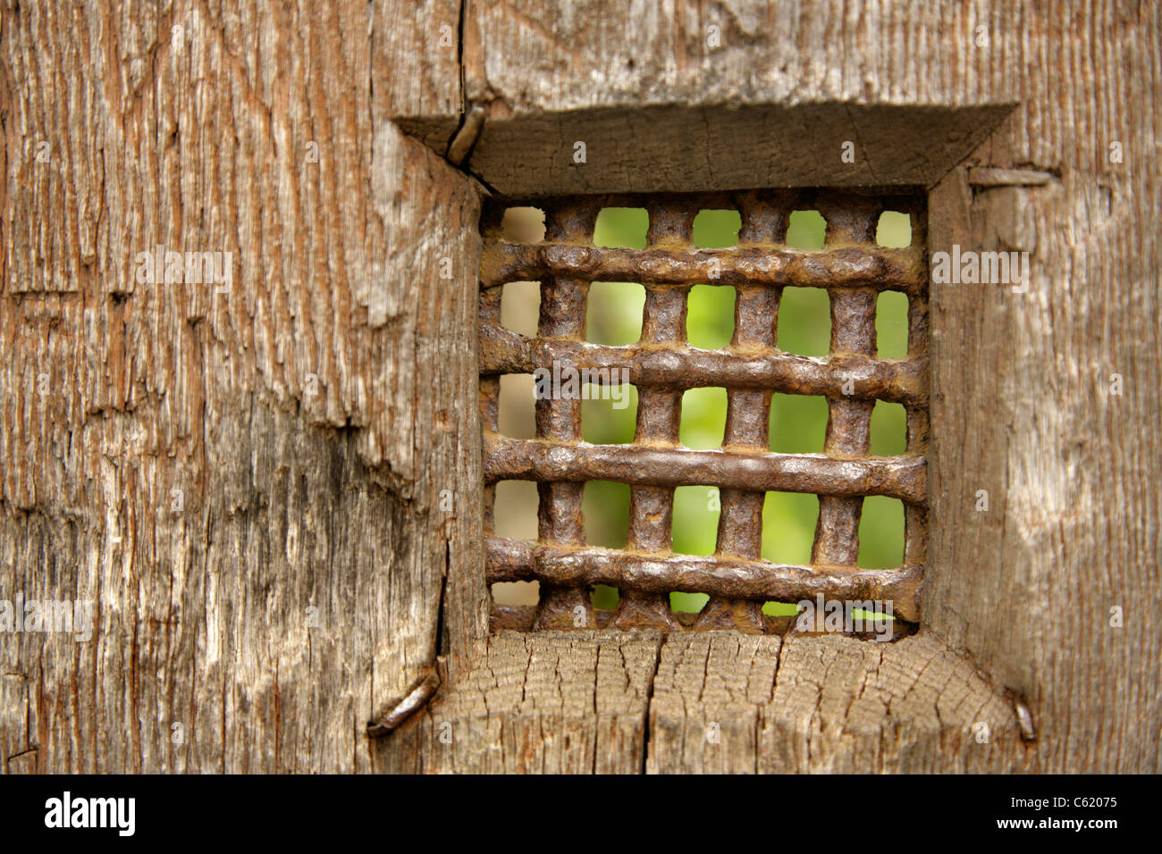 Small Barred Viewing Panel In Old Wooden Door Stock Photo