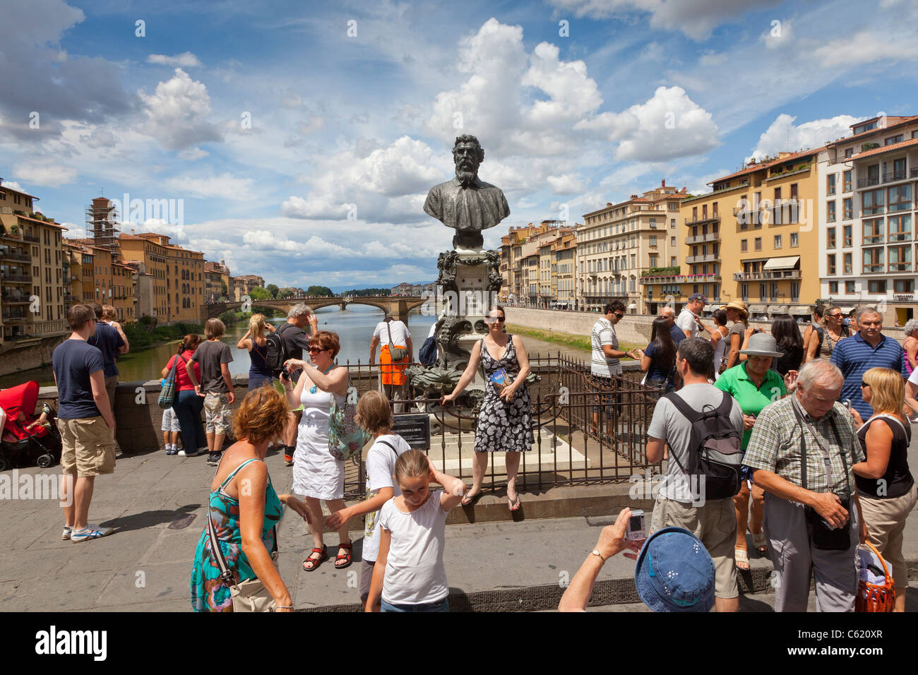 Tourists crowding the Ponte Vecchio, Bust Of Benvenuto Cellini Florence Tuscany Italy Stock Photo