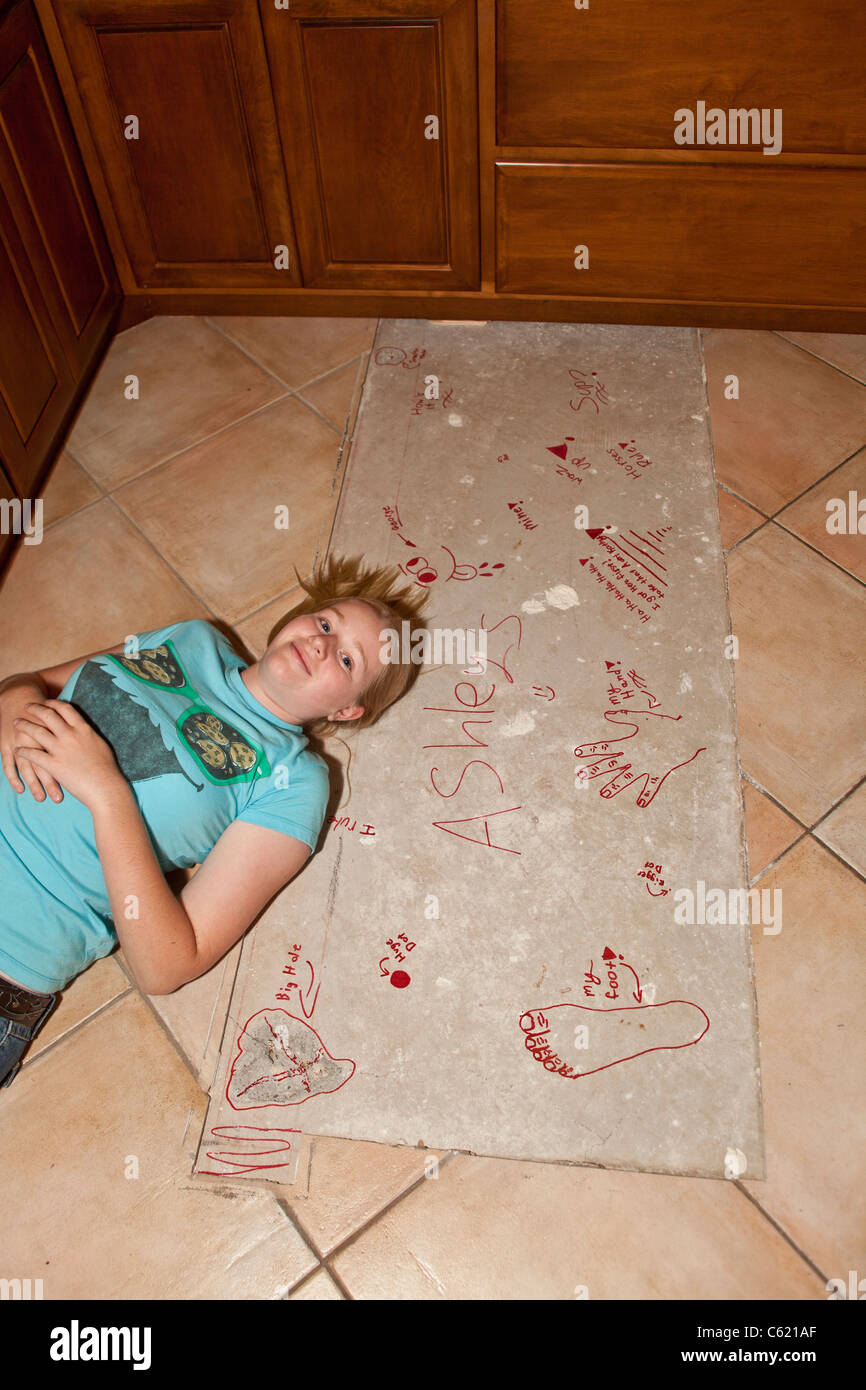 Teen girl writing on unfinished areas of kitchen remodel. MR Myrleen Pearson Stock Photo