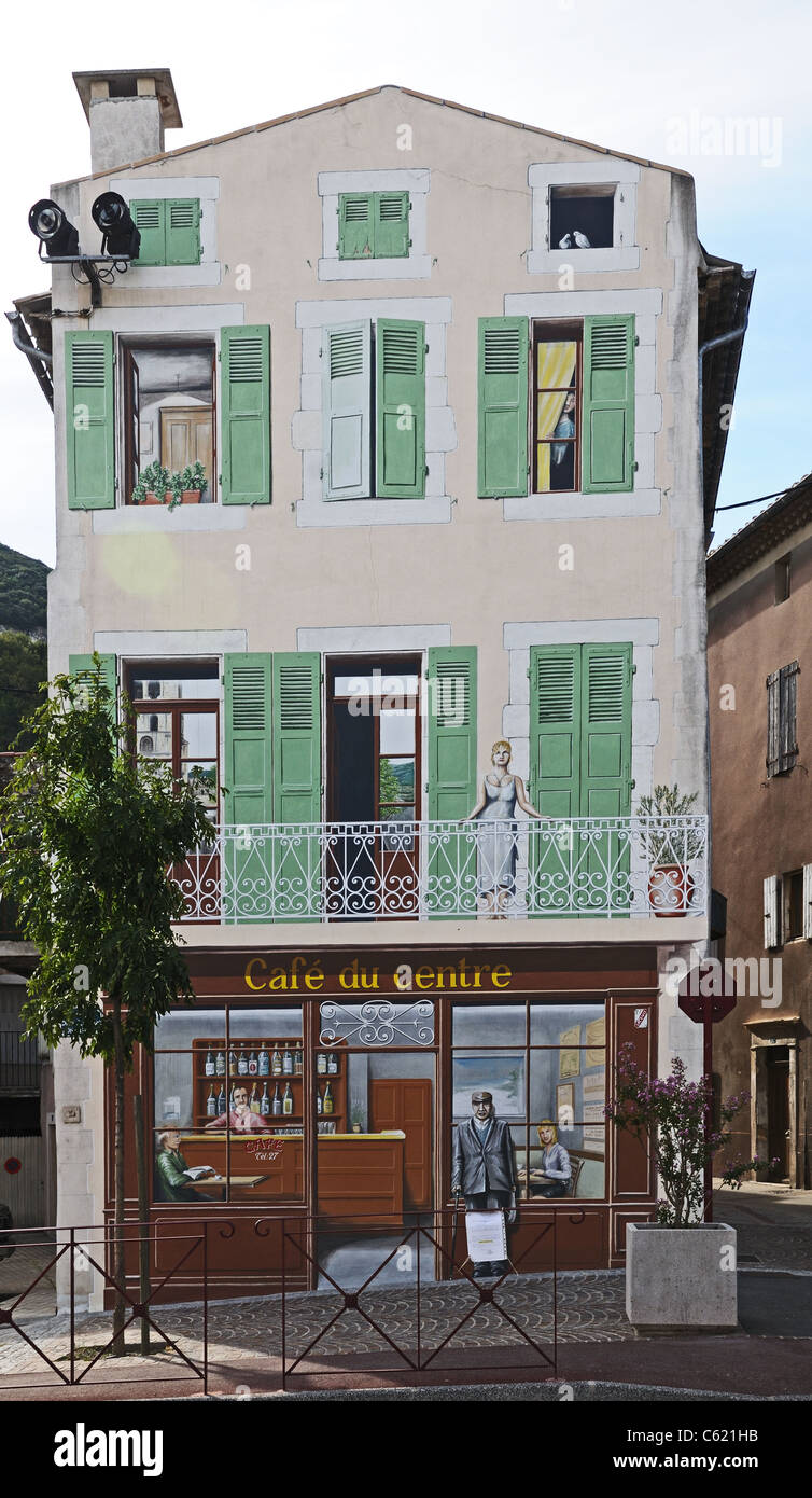 Painted building with “Café du Centre” trompe l’oeil painting on the wall showing café scene in Cruas in the Rhone Valley France Stock Photo