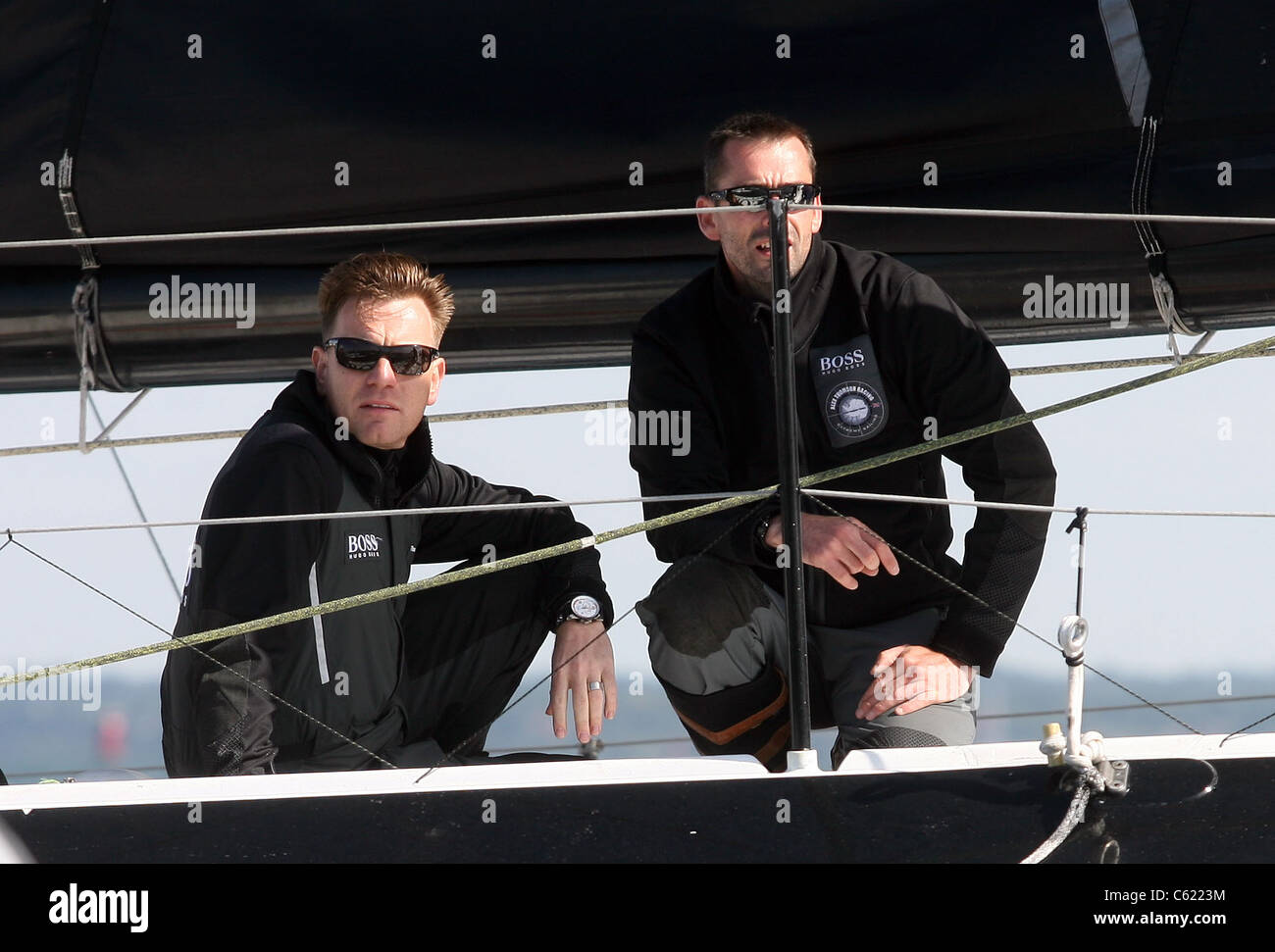 COWES, ISLE OF WIGHT -  Ewan McGregor talks to a crew member on board Hugo Boss skippered by Alex Thomson Stock Photo
