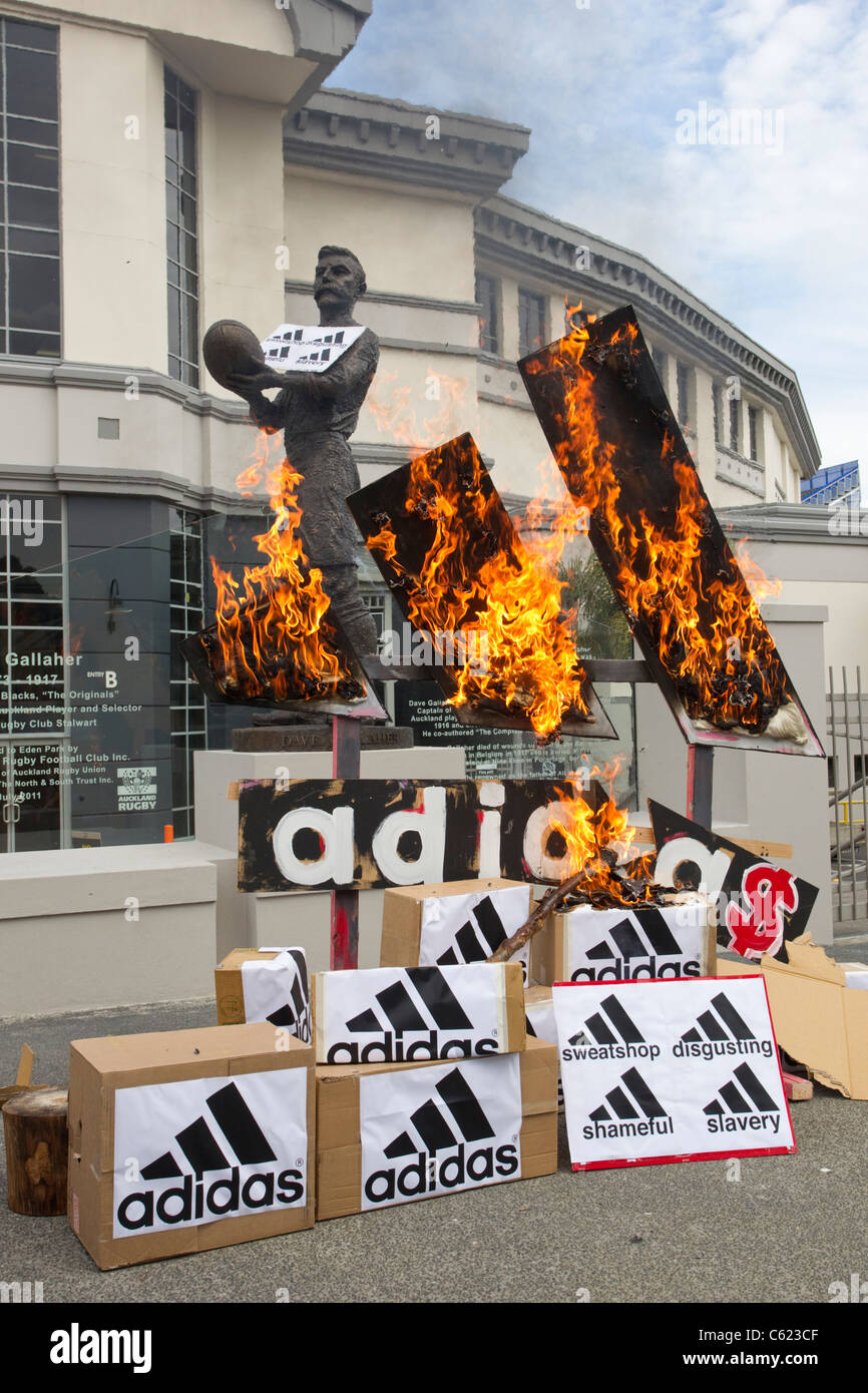Demonstrators set fire to mock Adidas Logo's and Boxes to protest against Adidas pricing of All Black Rugby Shirts Stock Photo