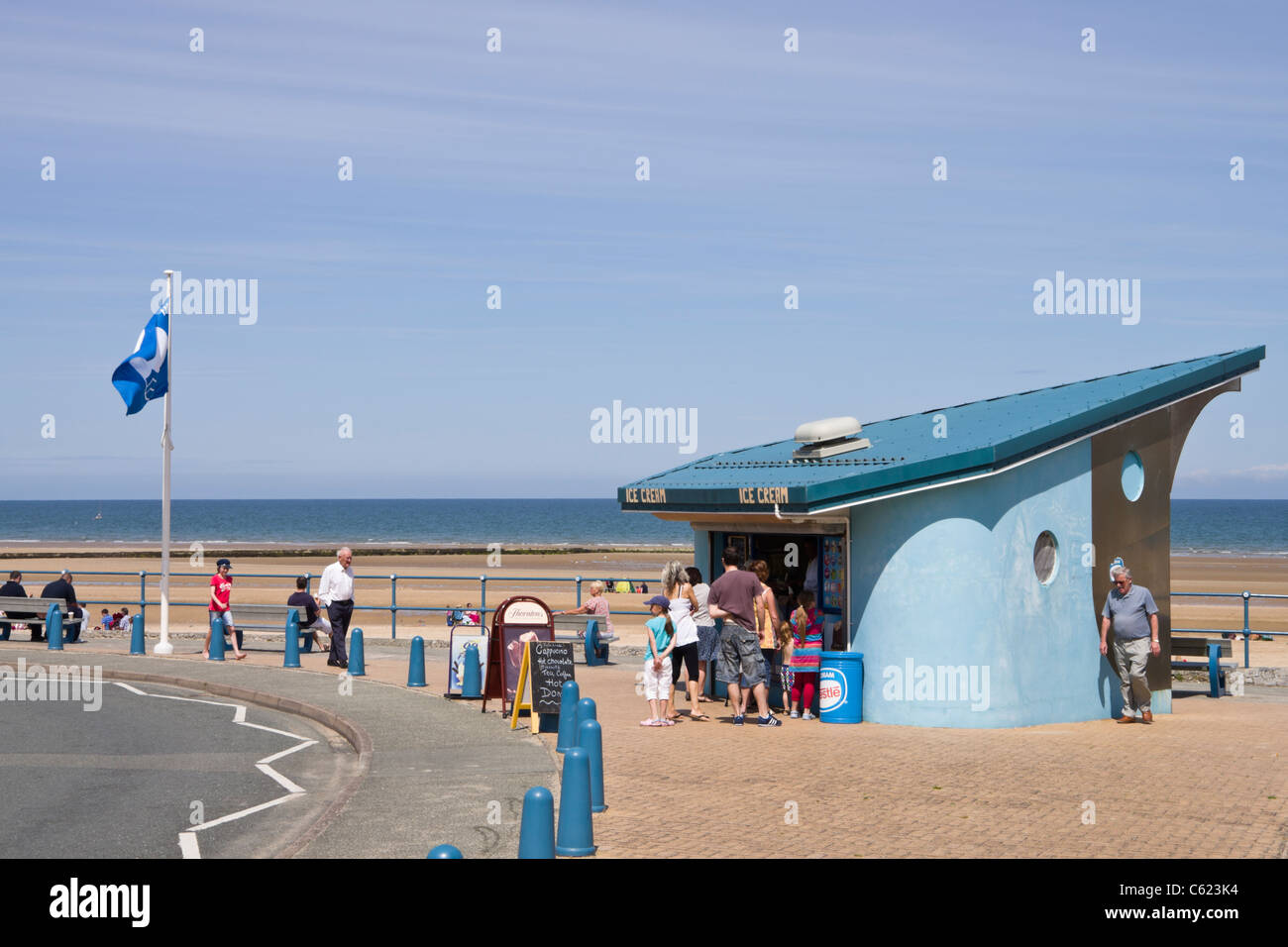 Ice cream parlour selling ice creams on seafront by beach in Welsh