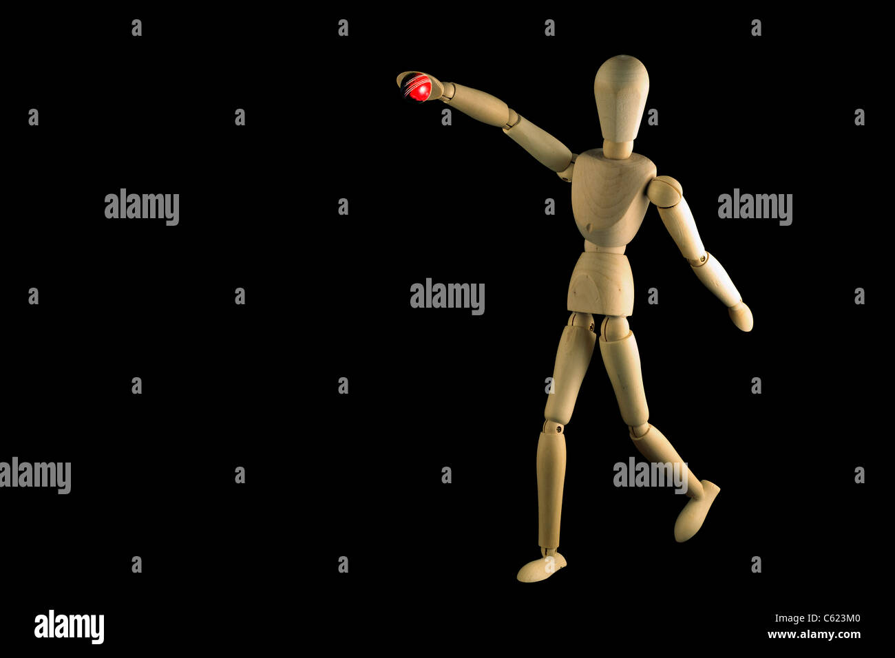 Mannequin cricket player shown bowling a ball isolated on black Stock Photo