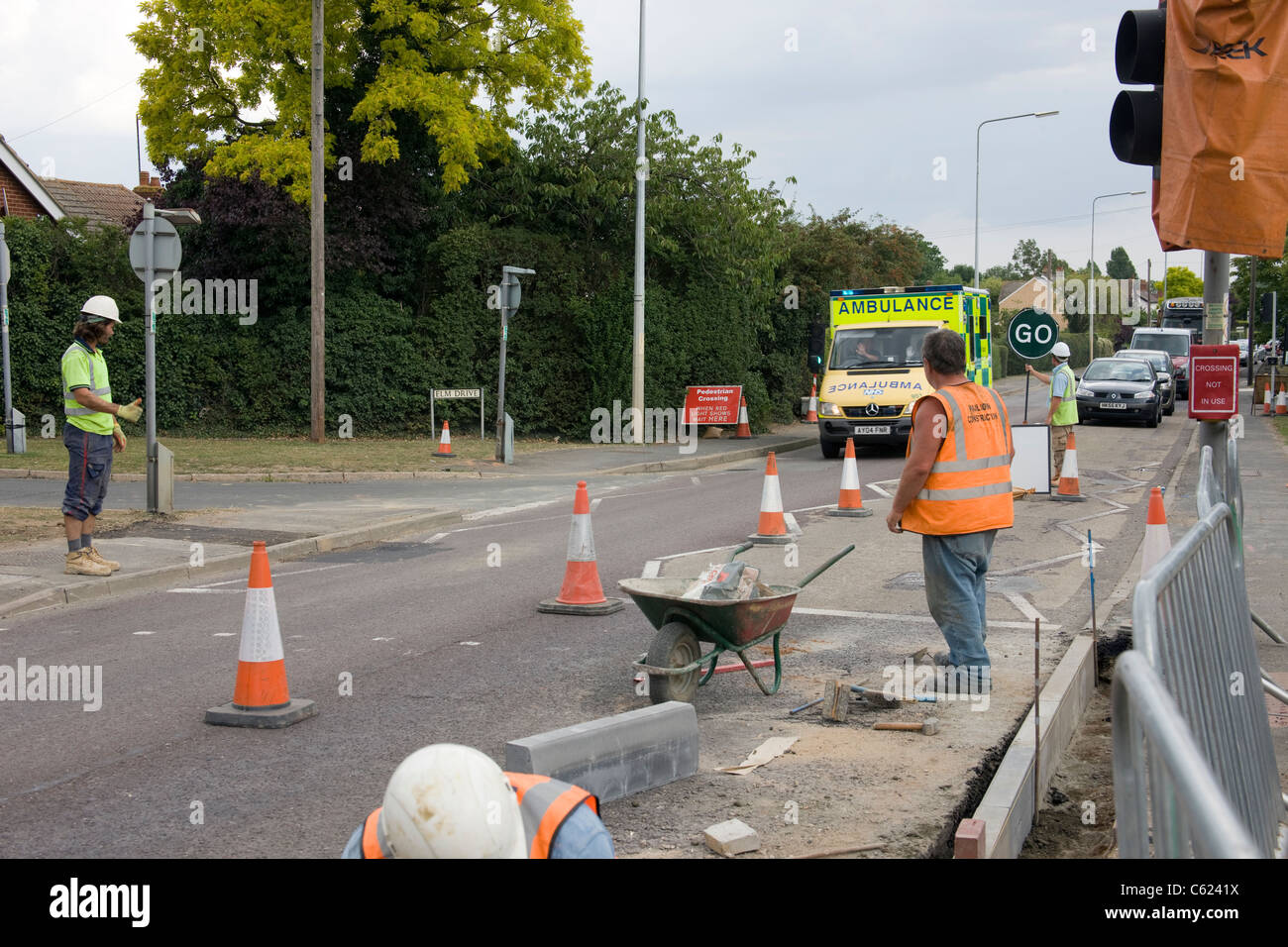 Traffic held up at road works by a manually operated traffic control to allow an Ambulance through . Stock Photo