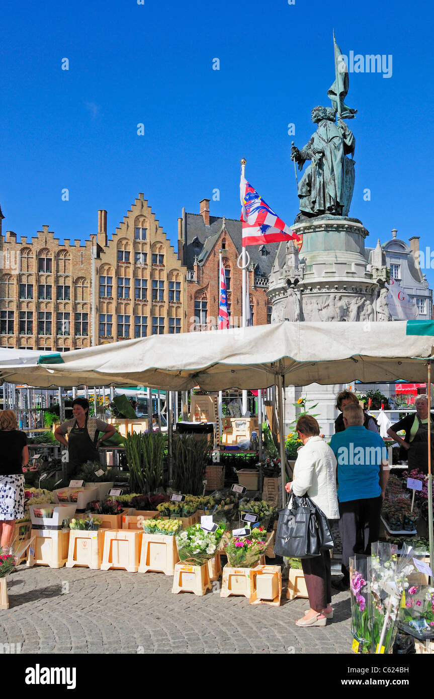 Bruges / Brugge, Flanders, Belgium. Markt - main market square. Flower Market stalls; statue of Pieter de Coninck + Jan Breidel Stock Photo