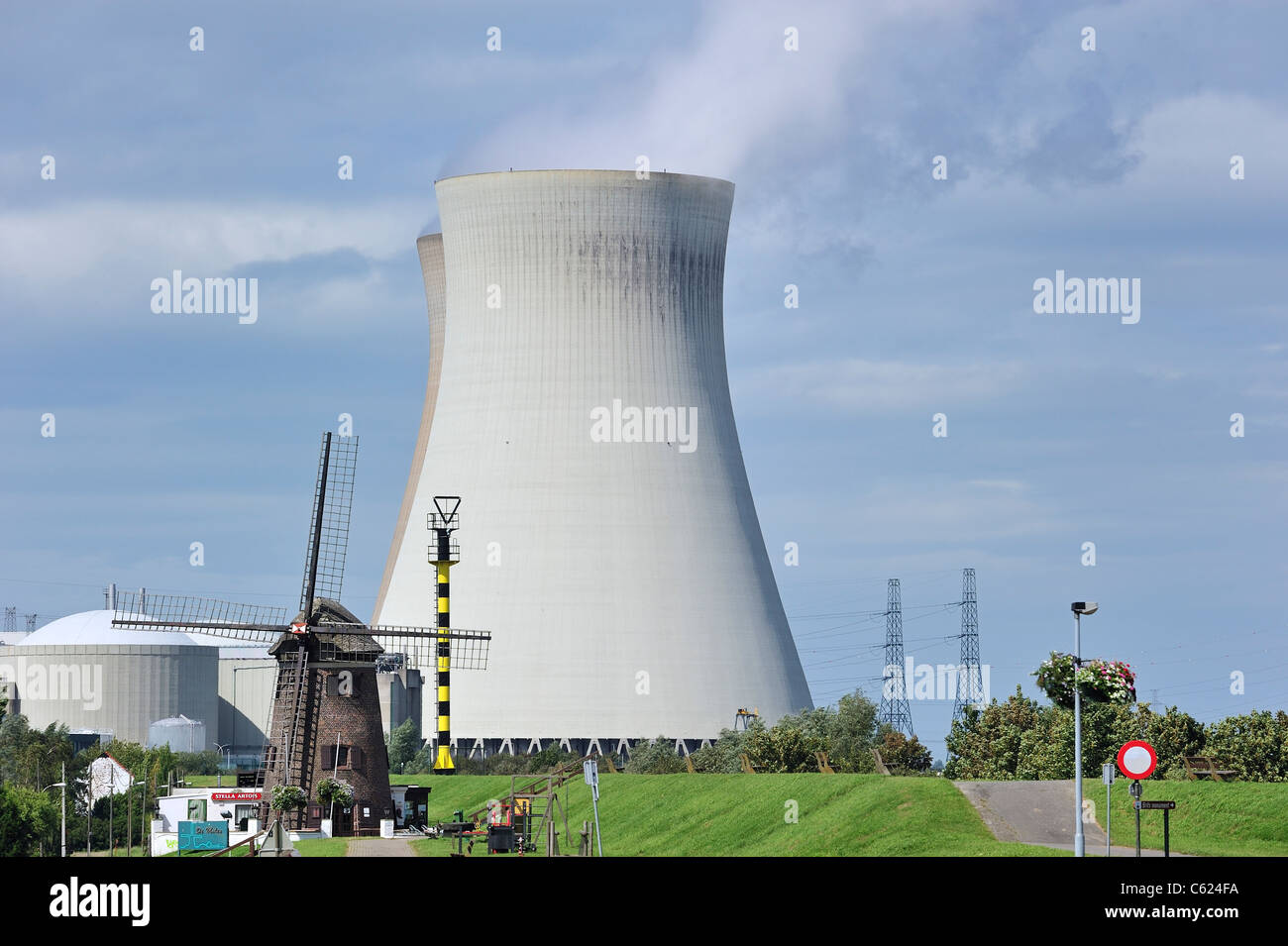 The windmill Scheldedijkmolen and cooling towers of the Doel Nuclear Power Plant along the river Scheldt at Beveren, Belgium Stock Photo