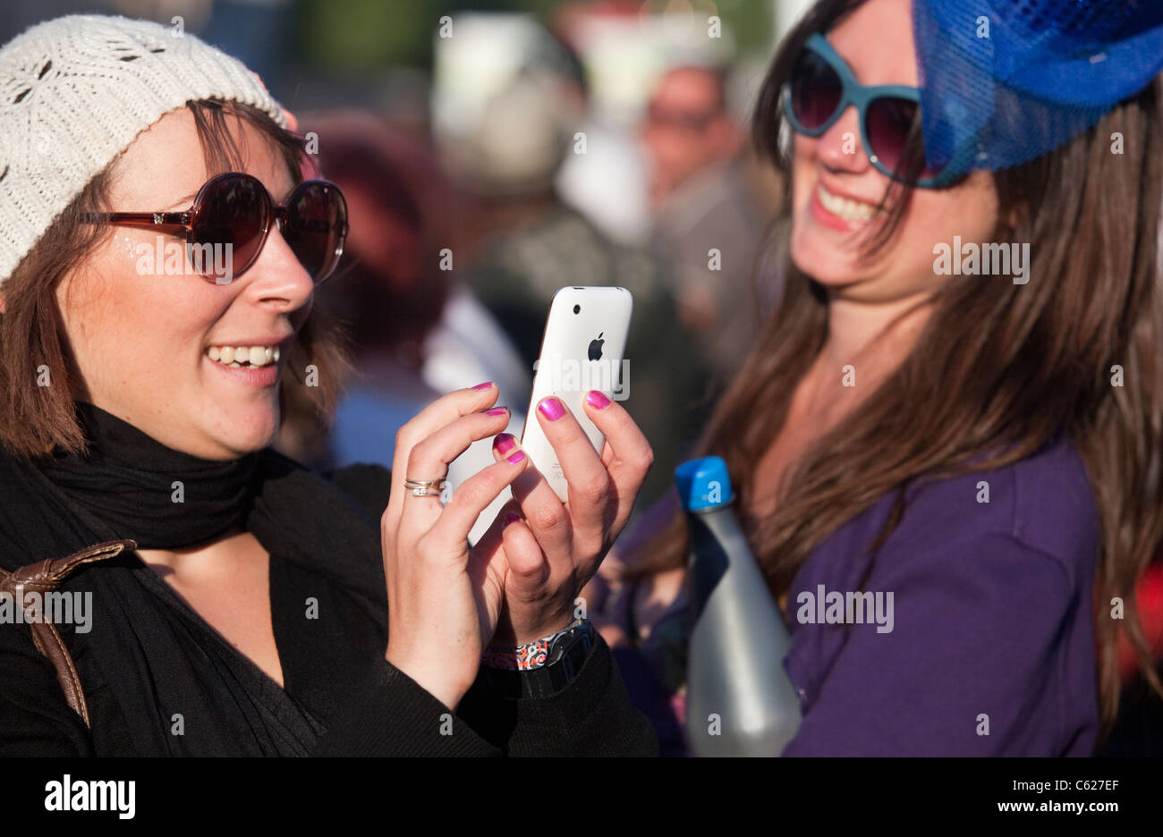 Woman using the Apple Iphone at a festival Stock Photo