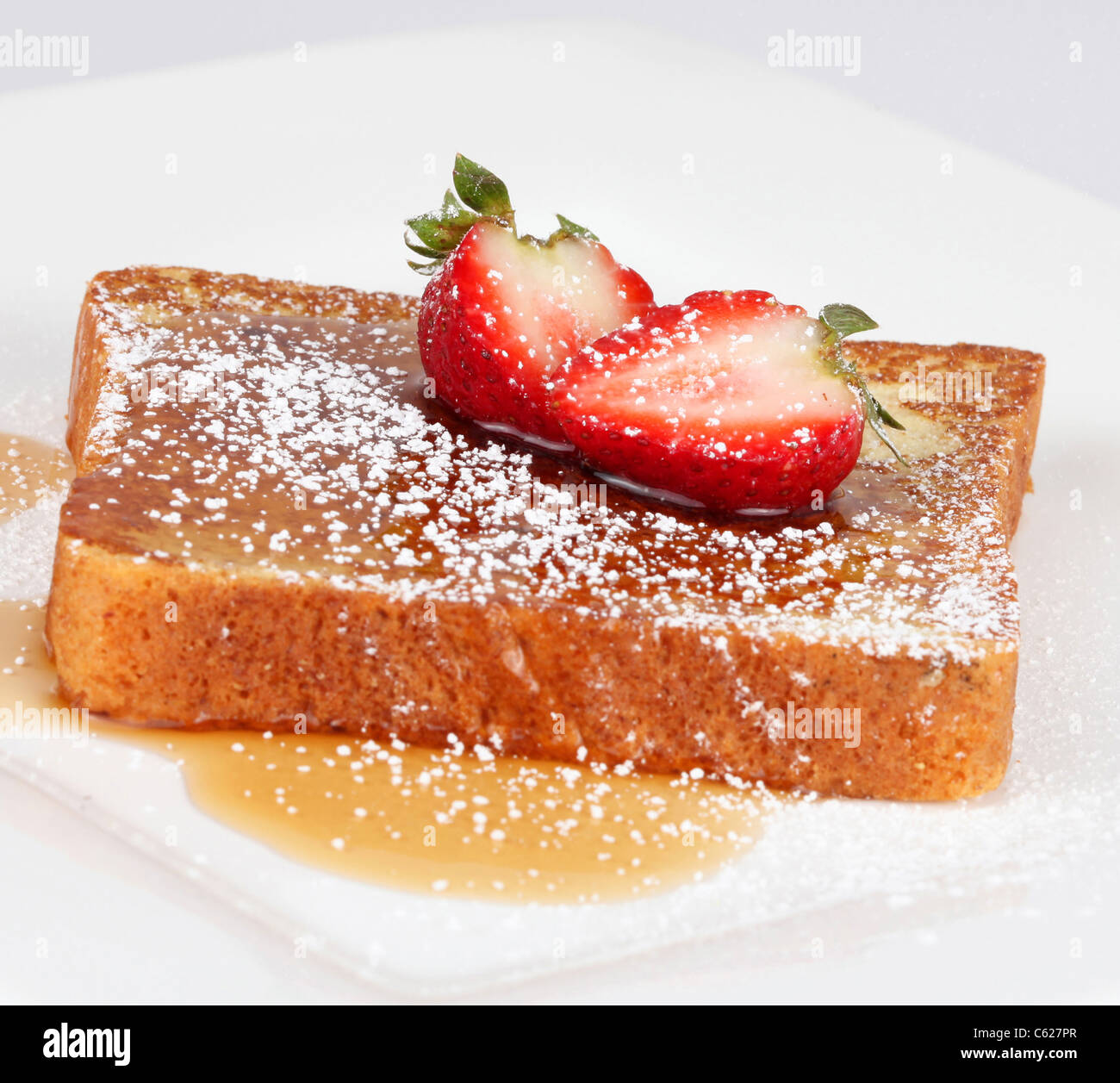 French toast with powdered sugar and a strawberry on white Stock Photo
