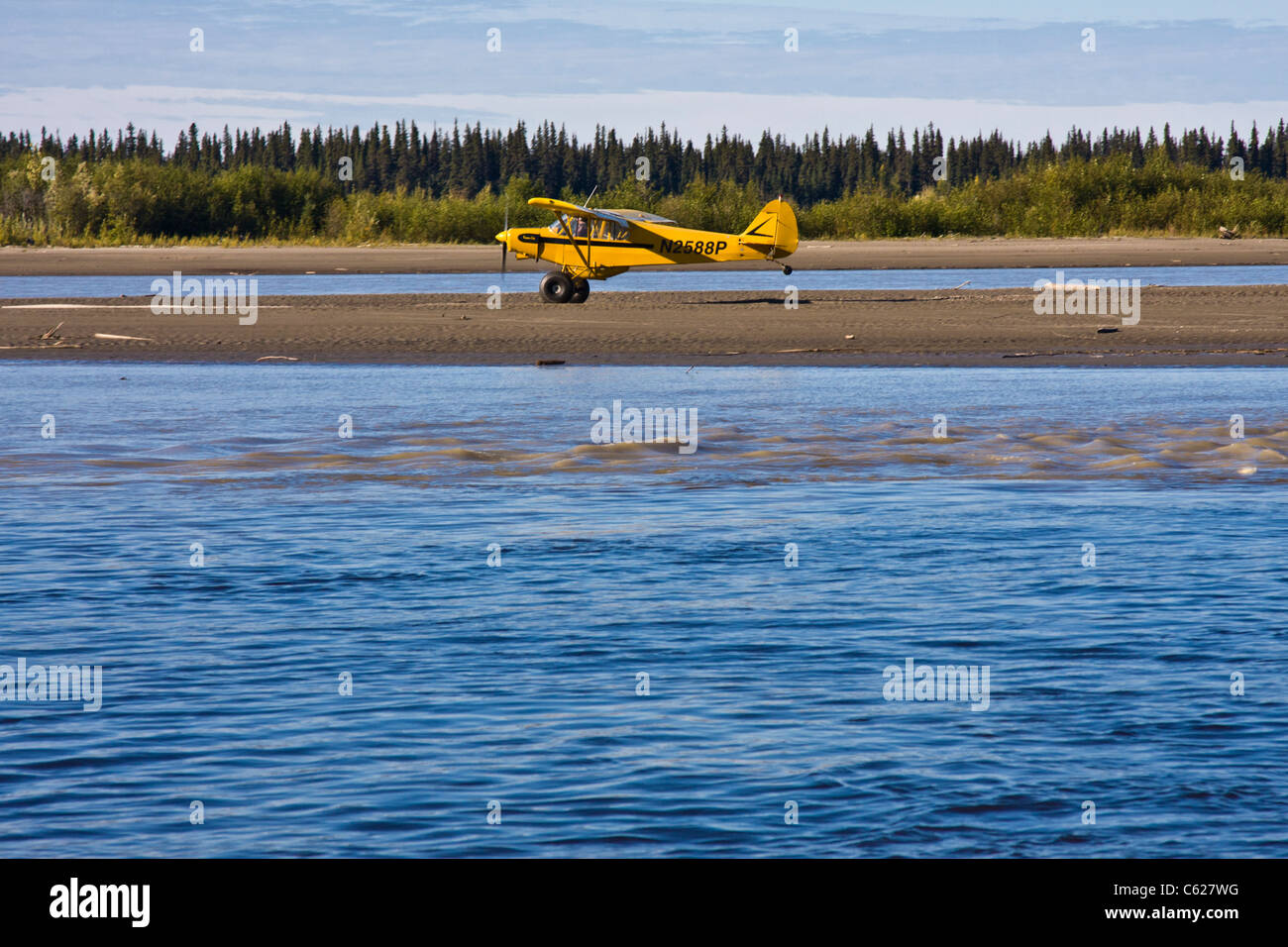 Small plane demonstrating taking off and landing on a narrow strip of land, a sand bar in the Chena River, at Fairbanks, Alaska. Stock Photo