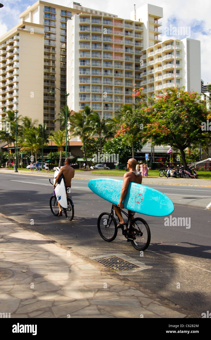 surfer on bike, Waikiki Beach Honolulu HI Stock Photo