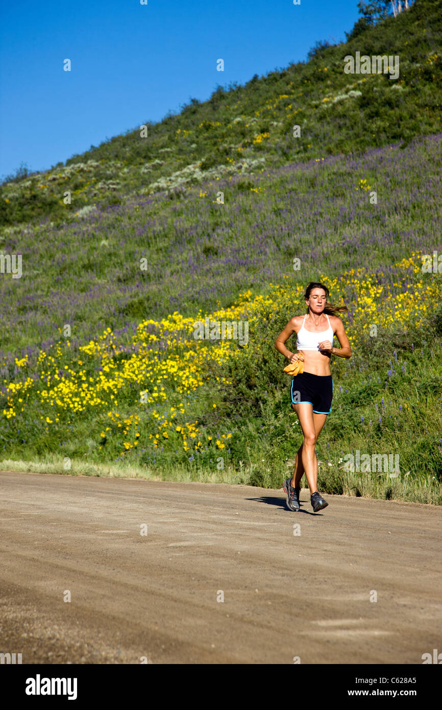 Female runner on Brush Creek Road near Crested Butte, Colorado, USA Stock Photo