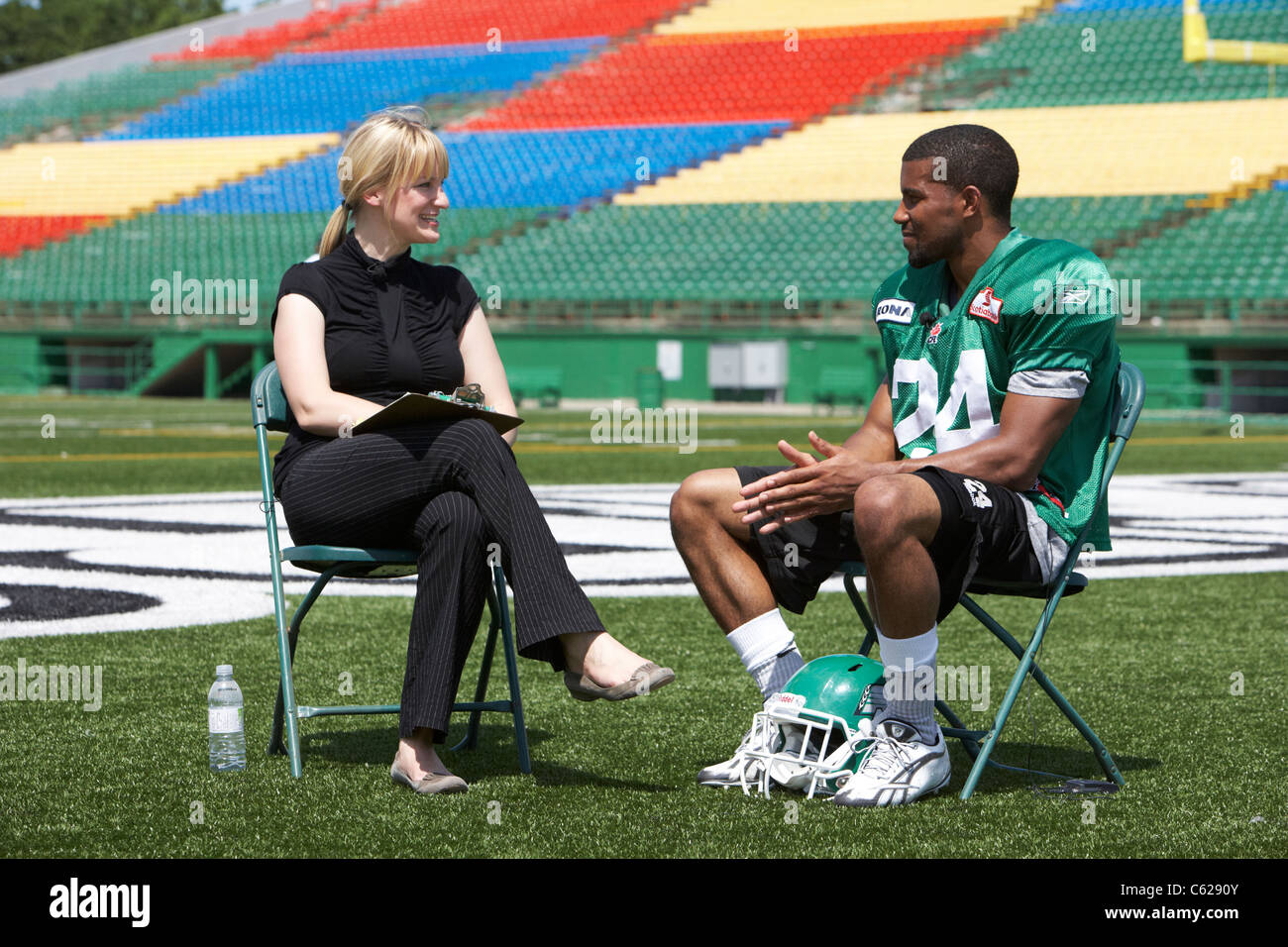 female interviewer interviewing yvenson bernard saskatchewan roughriders running back player mosaic stadium taylor field regina Stock Photo