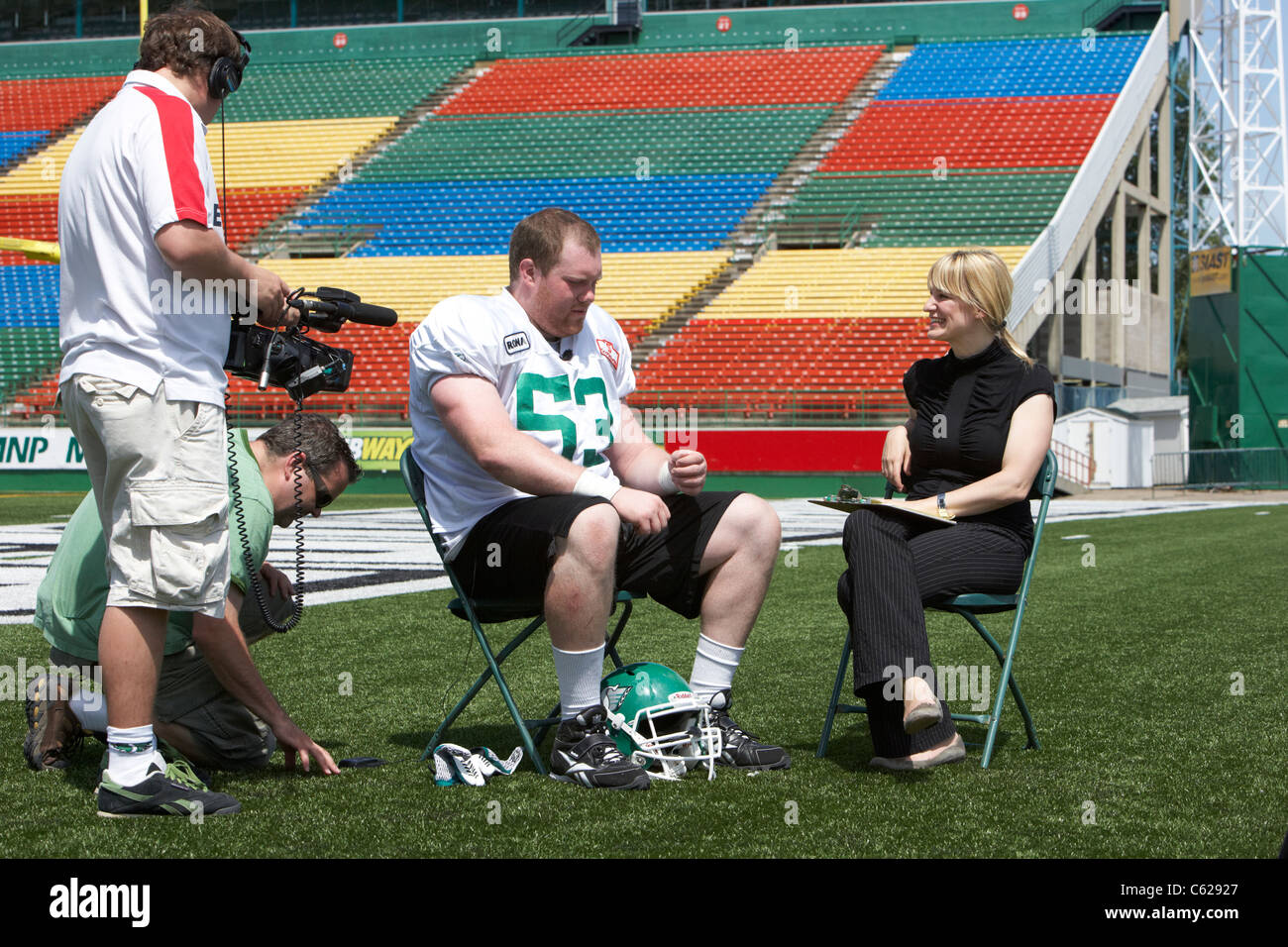 female interviewer interviewing patrick neufeld saskatchewan roughriders offensive lineman player mosaic stadium taylor field Stock Photo