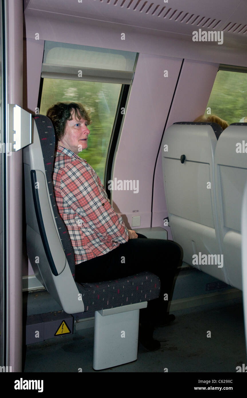 female passenger sitting in upstairs section of belgian railways double-deck inter-city train,brugge to brussel zuid Stock Photo