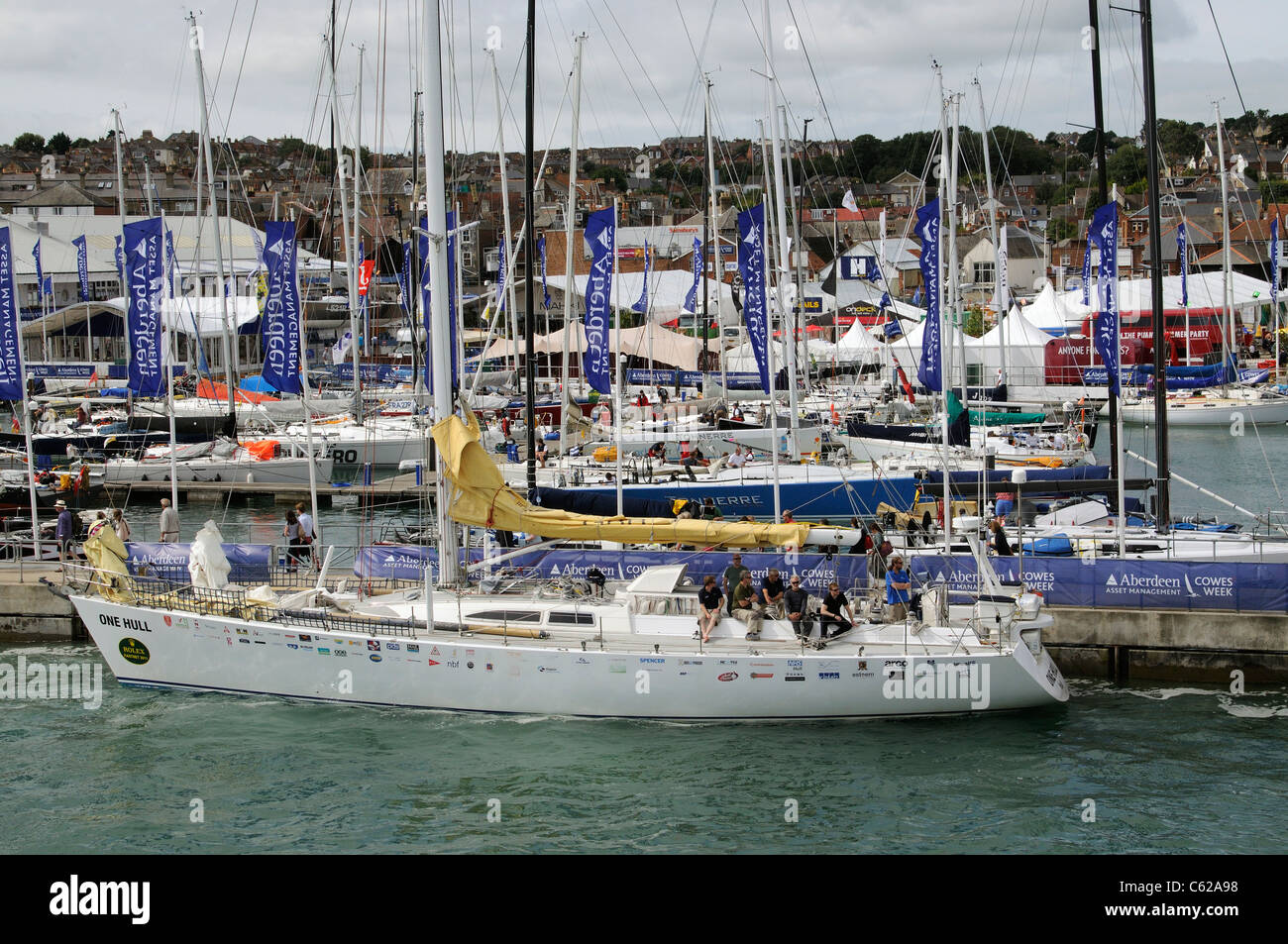 Rolex Fastnet Race competitors in Cowes IOW One Hull a Challenger 72 type yacht with crew relaxing on the River Medina in Cowes Stock Photo