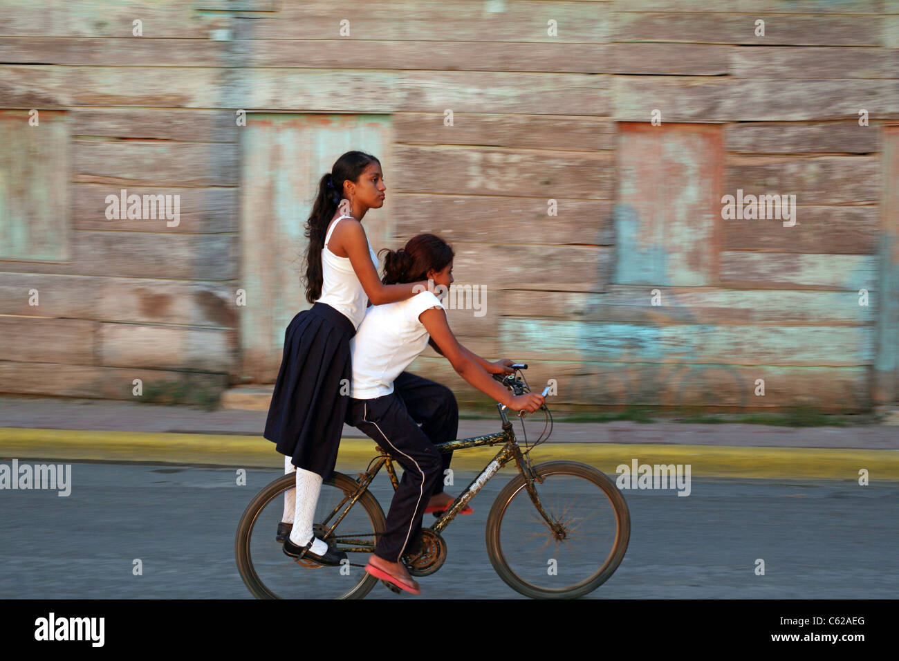Girls riding on a bicycle. San Juan del Sur, Rivas, Nicaragua, Central America Stock Photo