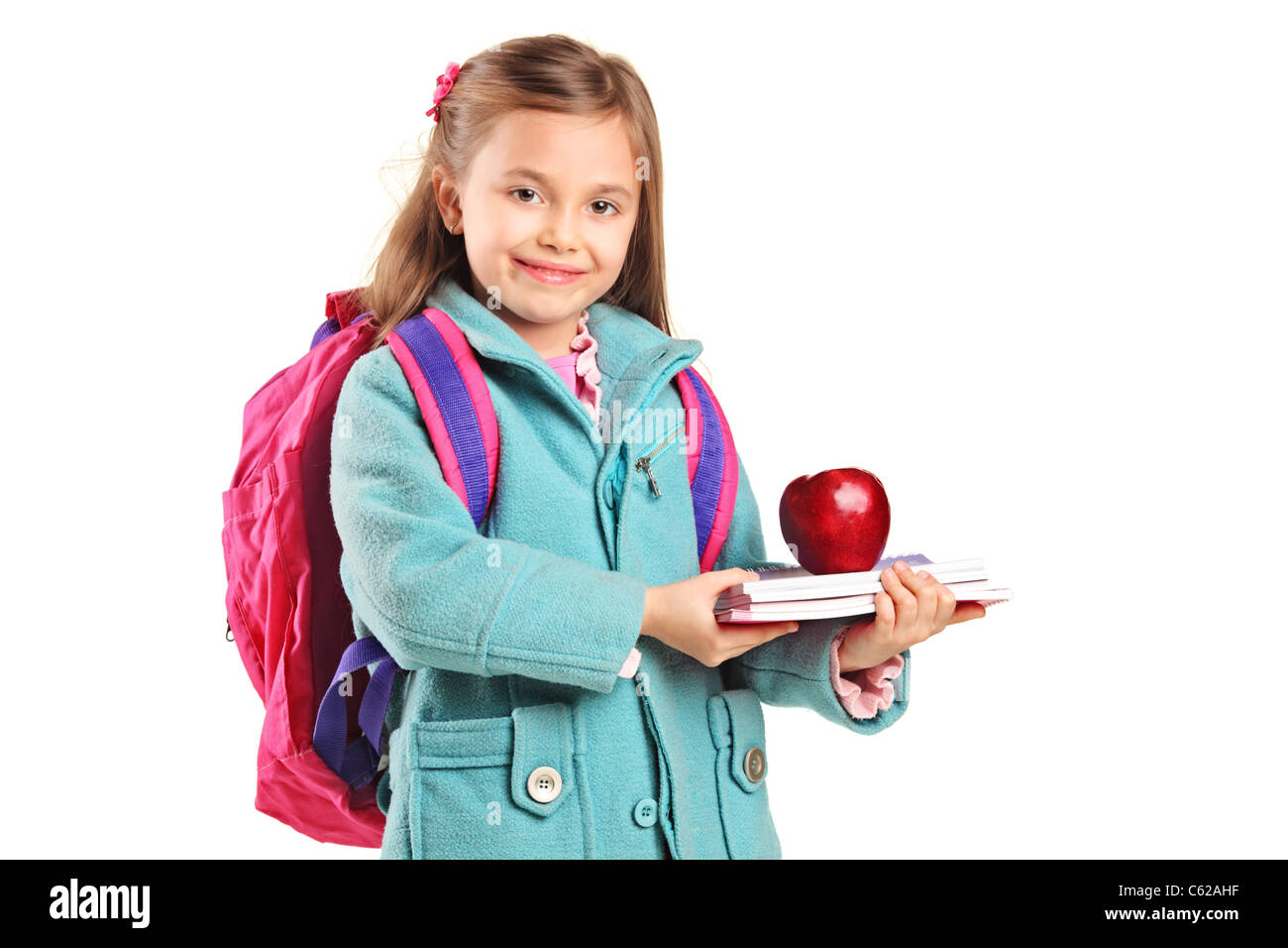 A school girl with backpack holding notebooks and red apple Stock Photo
