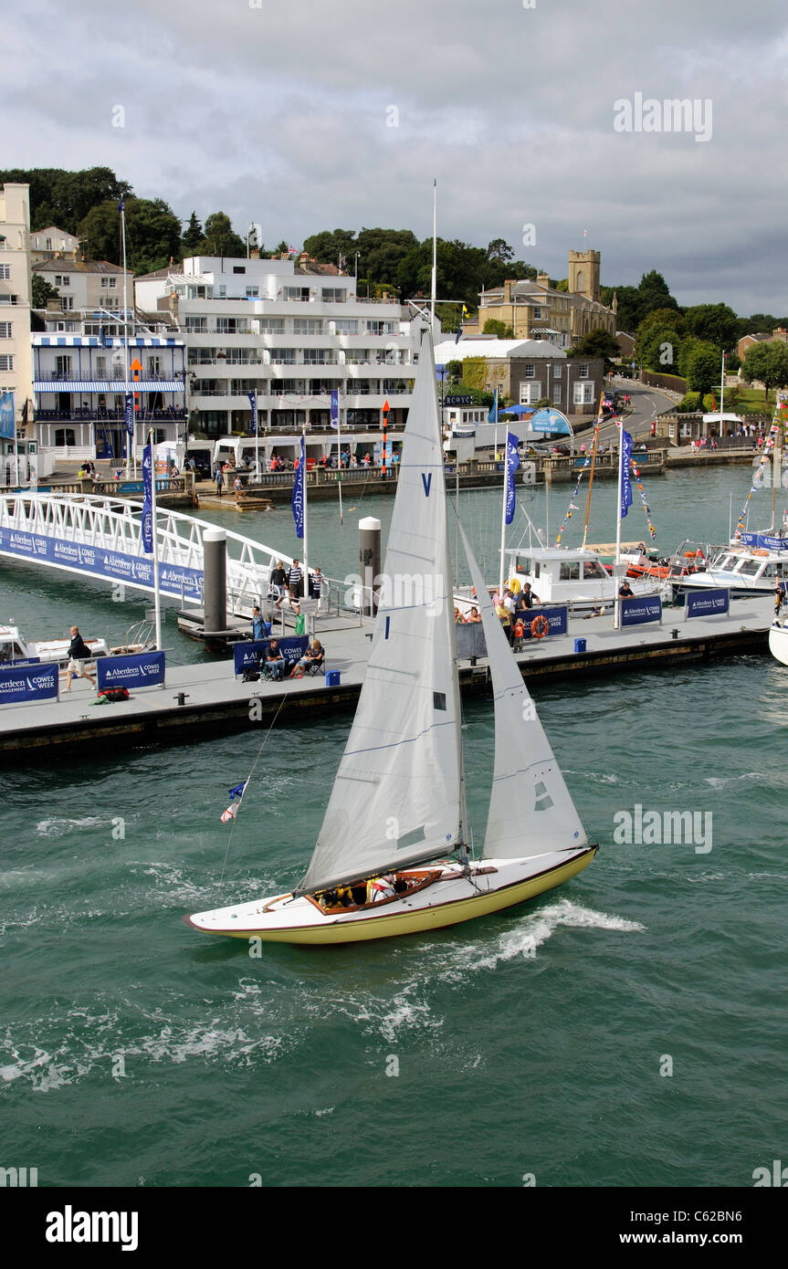 Sailing boat underway on the River Medina during Cowes Week Backdrop of Cowes waterfront Isle of Wight England Uk Stock Photo