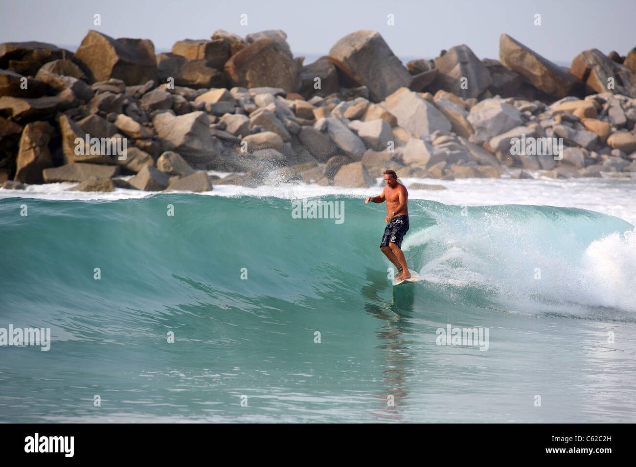 Surfer cruising on a small glassy wave in Mexico. Stock Photo