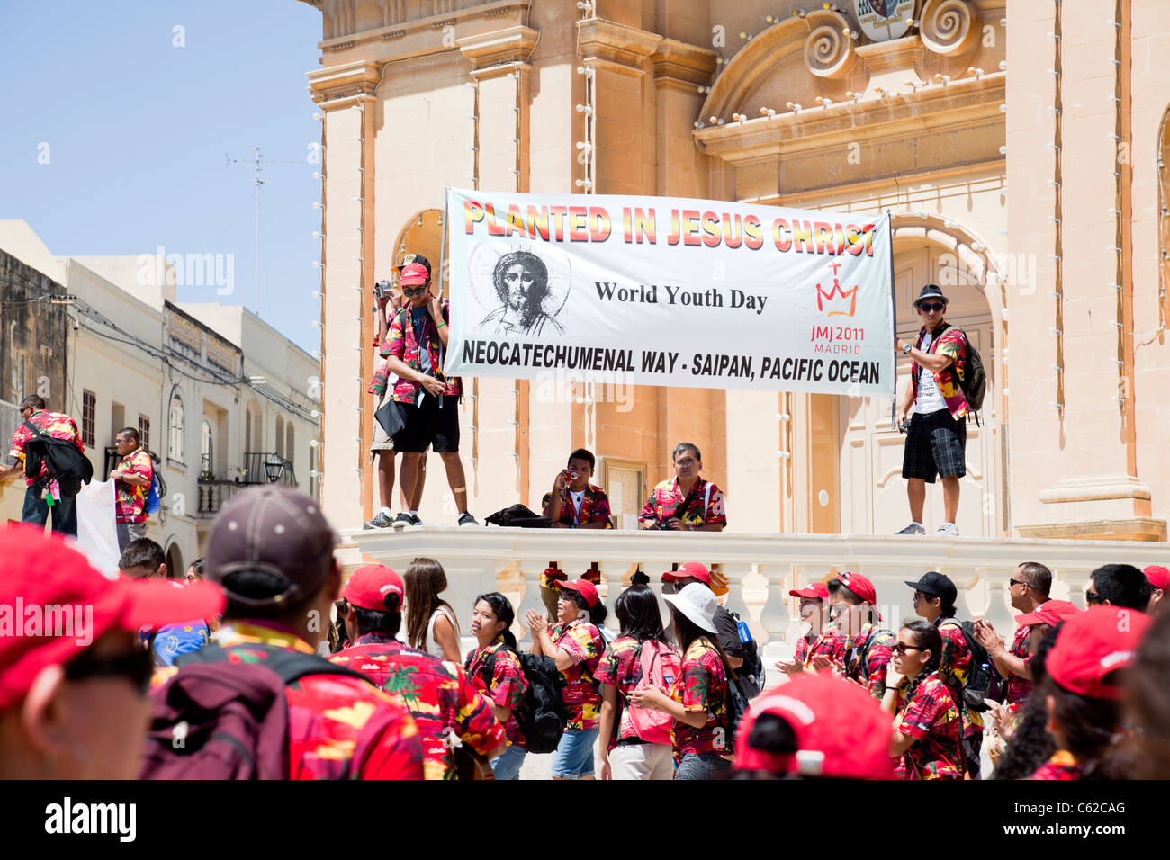 Group of religious people from Guam in colorful red shirt gather together on the World Youth Day in Marsaxlokk, Malta. Stock Photo