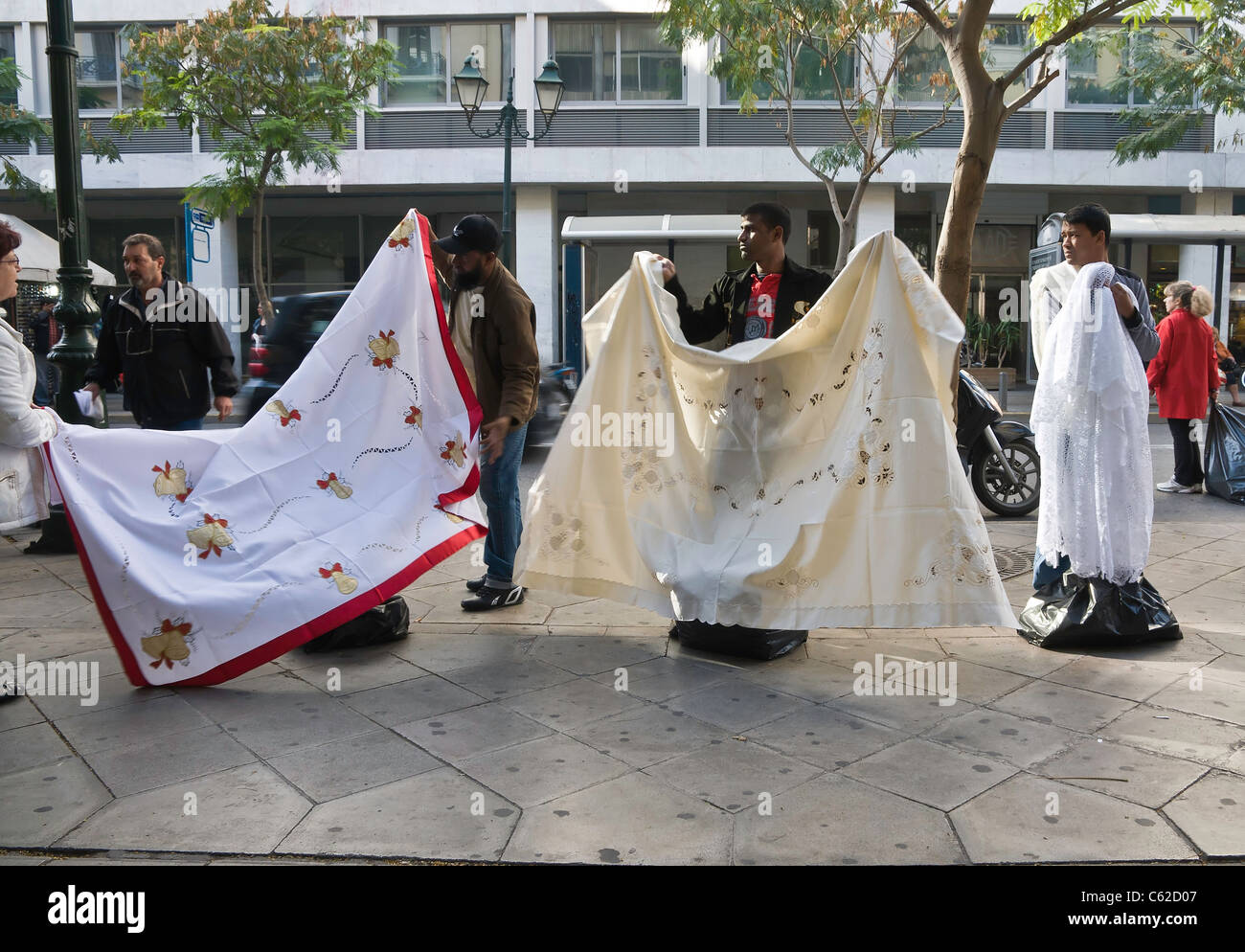 Immigrants selling tablecloths on Athinas street, in the centre of Athens, Greece Stock Photo