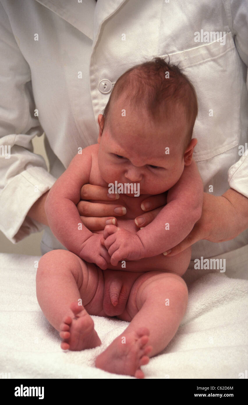 physician holding tiny baby boy Stock 