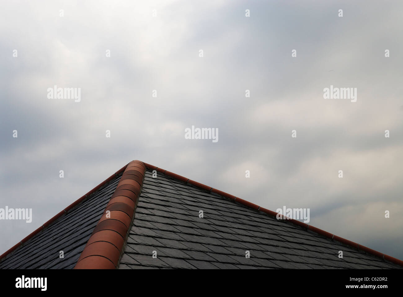 A tiled roof sits beneath a brooding sky. Stock Photo