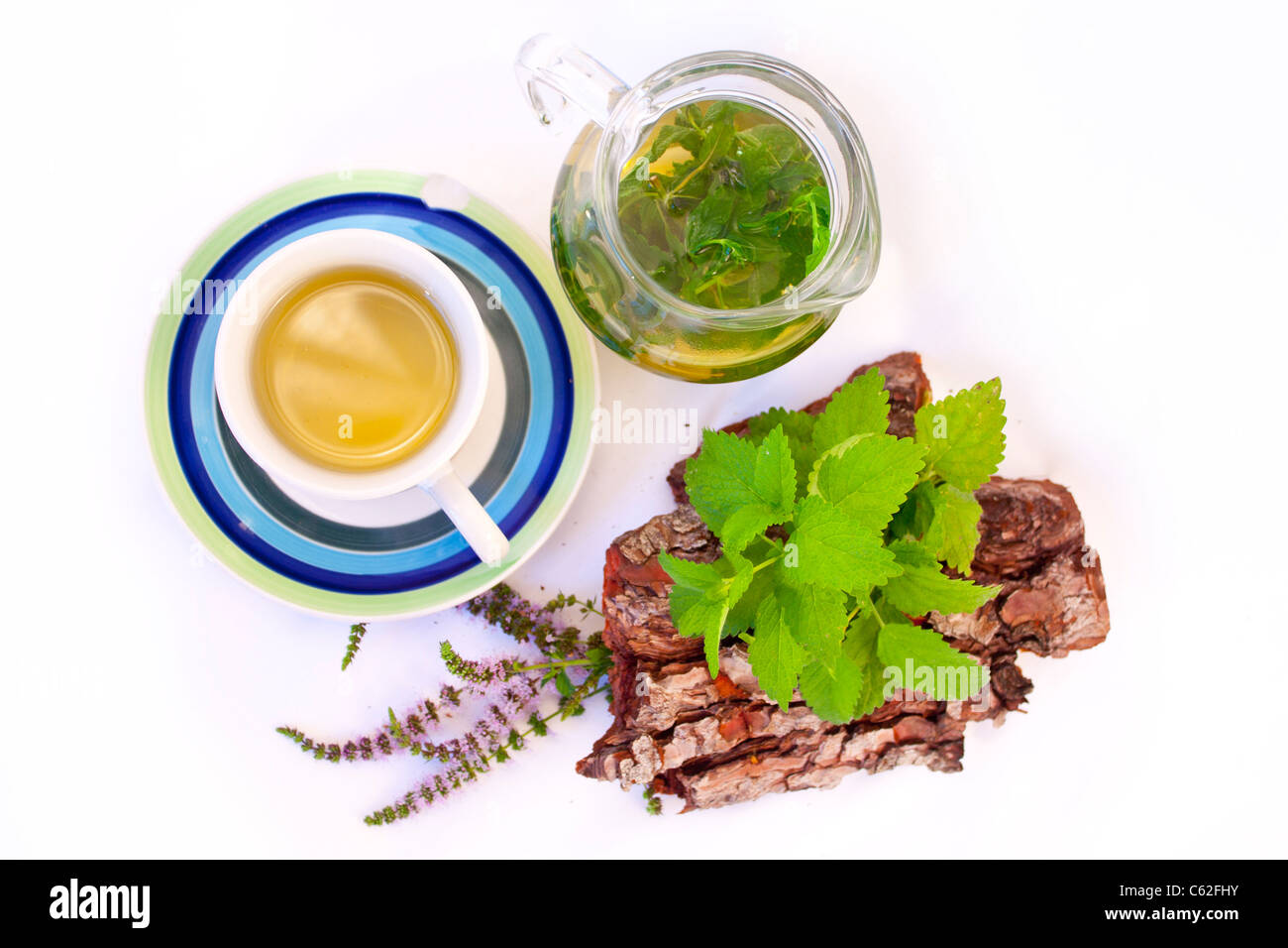 Lemon balm accompanied by a hot pitcher and a wood bark with leaves Stock Photo