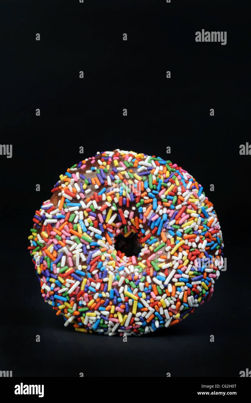 Rainbow sprinkled doughnut. Stock Photo