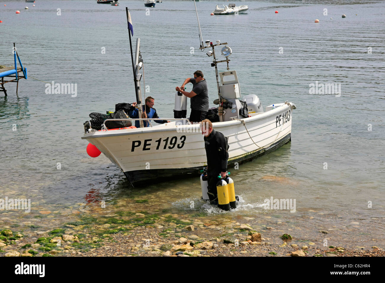 A small boat carrying recreational divers with all their underwater gear on a weekend away from the day job Stock Photo