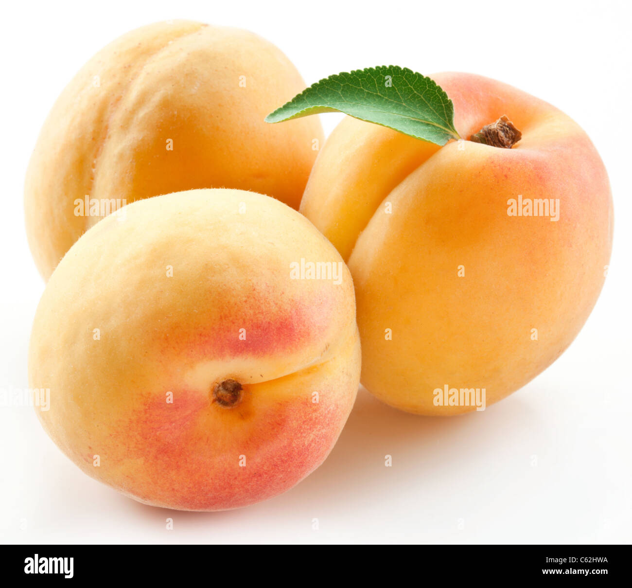 Apricots with leaves on a white background Stock Photo - Alamy