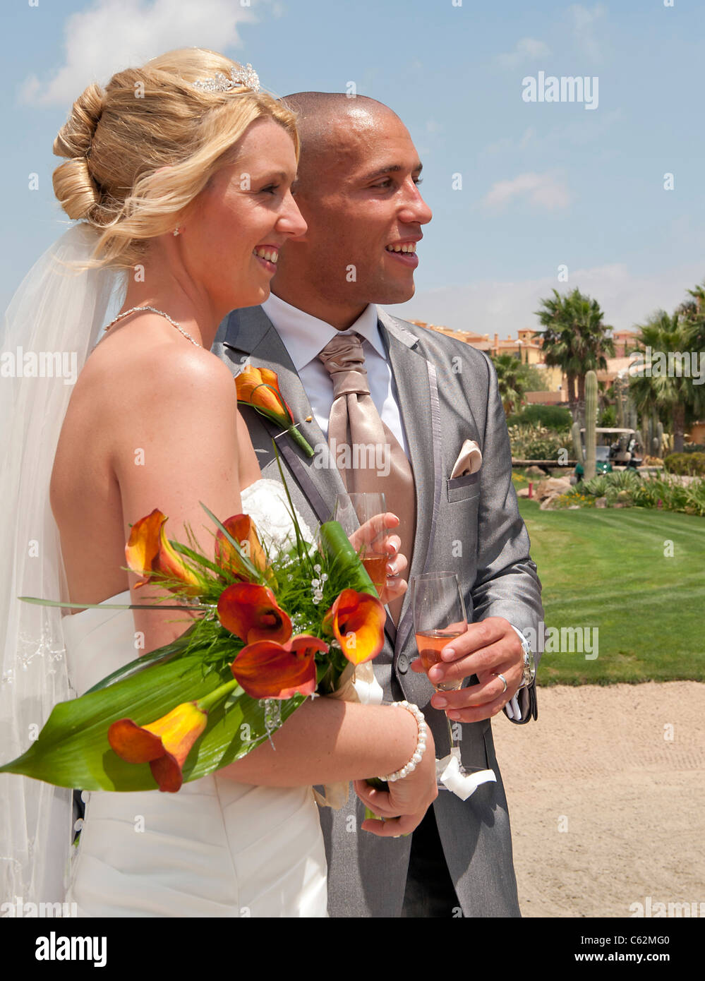 Bride and Groom enjoying a moment in the sunshine at the reception at a ...